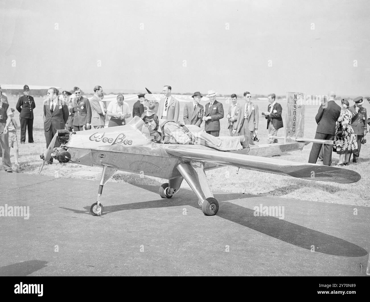 LE PLUS PETIT AVION du MONDE le "WEEBEE", le plus petit avion piloté au monde, a participé aujourd'hui au concours aérien international à l'aéroport de Gatwick, organisé en aide au fonds de bienfaisance de la Royal Air Force. Conçu et construit par 3 jeunes ingénieurs aéronautiques américains, il a une envergure de seulement 15 pieds, et est si petit qu'un homme peut le soulever du sol. Le pilote est couché sur le ventre au-dessus du fuselage, auquel il est attaché par harnais, et atteint les commandes à travers les emmanchures. L'IMAGE MONTRE:- la ' PETITE ABEILLE ' à l'aéroport de Gatwick aujourd'hui montrant le pilote, KARL MONTIJO , attaché en position de voler Banque D'Images