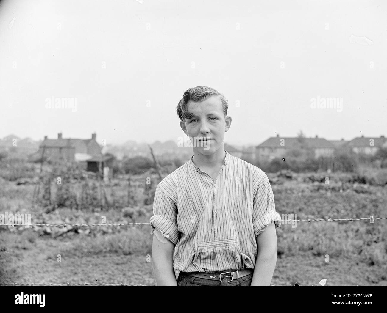 GARÇON, 14' SAUVE UNE FEMME D'UN INCENDIE DANS LEQUEL CINQ MOURURENT à travers un mur de flamme , Dennis Wheeler, 14 ans de Seymour Road , stable Hill , Bristol traîna Miss Ann Bennett ,, âgée d'environ 50 ans , d'un incendie qui détruisit la maison du conseil de Seymour Road occupée par Mr. Lew Tippett , sa femme , Rose , et leurs six enfants . Mme . Tippett et quatre des enfants ont péri dans l'incendie. Dennis jouait au football dans la rue quand il a vu les flammes , a donné l'alarme et a couru à la porte d'entrée de la maison . L'IMAGE MONTRE:- DENNIS WHEELER après le sauvetage. 25 août 1949 Banque D'Images