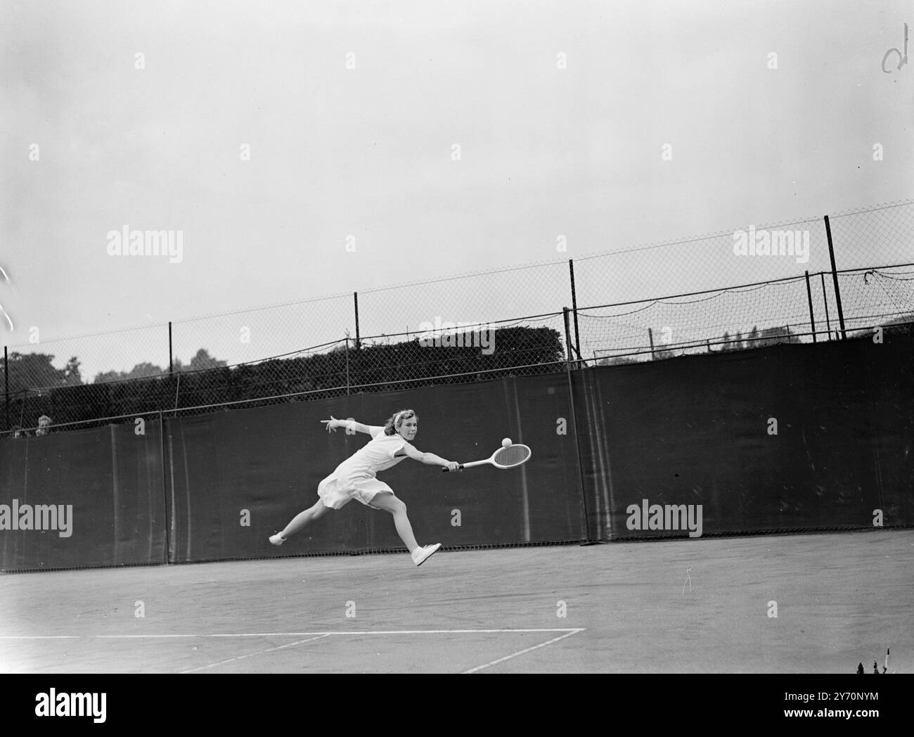 LA JEUNE fille de FINALE avec la longue foulée est JEAN PETCHELL, 16 ans, de Nottinghamshire , photographiée alors qu'elle marquait une victoire surprise facile sur ROSEMARY BULLUIED du Devon . Dans la demi-finale des singles filles des champions britanniques juniors de tennis sur gazon à Wimbledon , Londres . Mlle Petchell a gagné 6-0 6-1 . Miss Bullied était la graine No.1 et favorite pour le titre. 4 septembre 1949 Banque D'Images