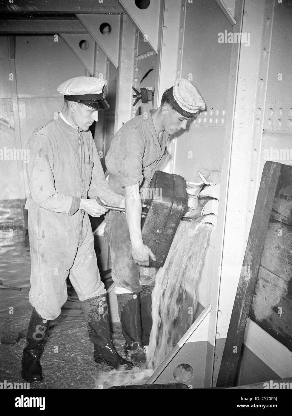 RÉPARATION D'Un TROU D'OBUS H.M.S.Phoenix est le nom qui a été donné à l'école de défense de la Royal Navy à Stamsure, près de Portsmouth, qui est sous le commandement du Capt C.W. Greening, D.S.C., R.N. les écoles de contrôle des dommages et de lutte contre les incendies de la Royal Navy venaient d'être fusionnées avec la formation de guerre chimique établie dans l'école, dont l'objet est de maintenir les navires flottants, en mouvement et se battant qu'ils ont été endommagés par l'action ennemie. L'expérience en temps de guerre a souligné la nécessité d'une plus grande attention à l'aspect défensif de la lutte contre un navire, et que l'école inst Banque D'Images