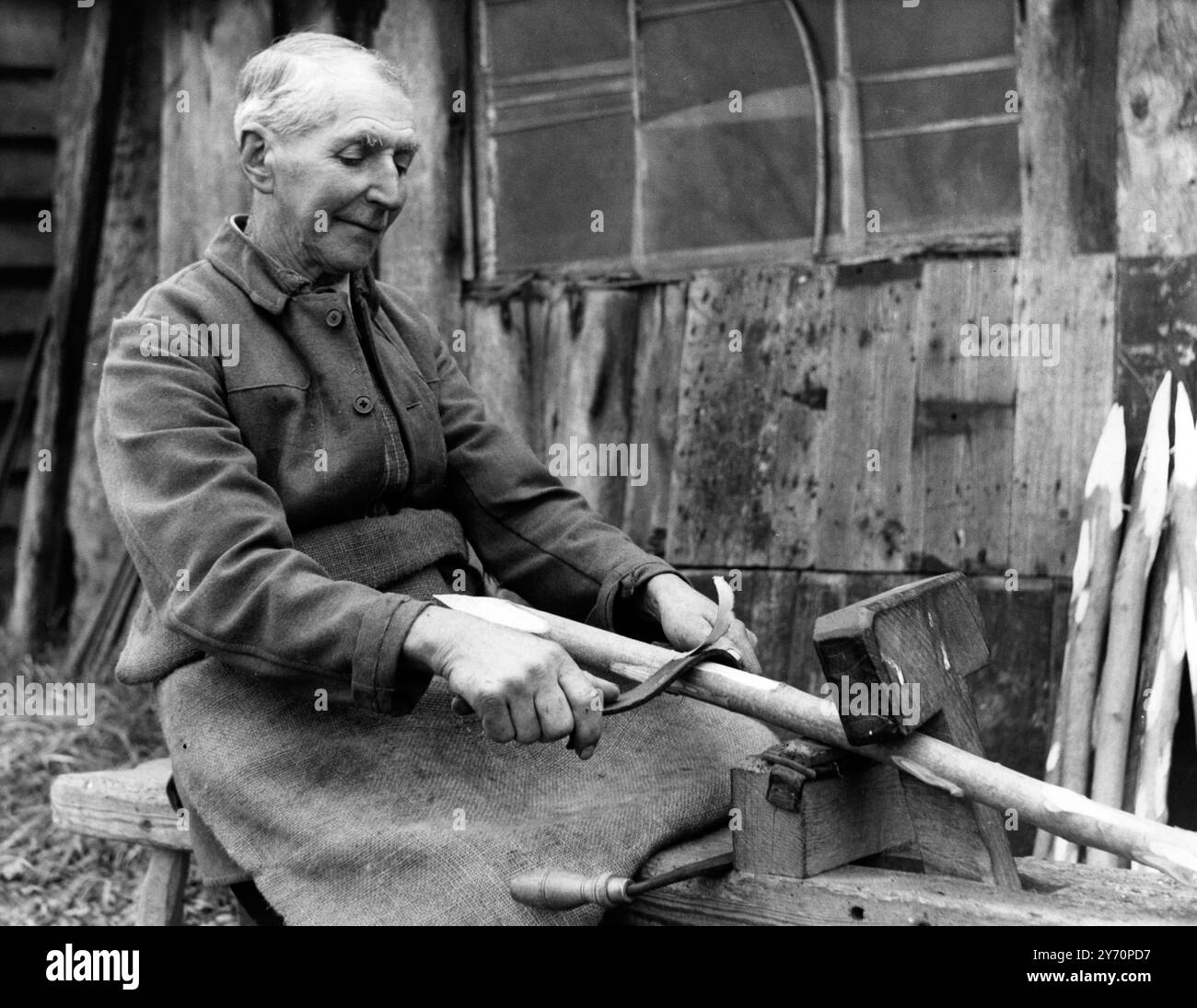 Artisan à Besom balais - - bois pour poignées est acheté chez les marchands locaux , ou d'un domaine . Il doit tomber et se préparer dans chaque cas. Le bouleau ou bruyère (et balai) qu'il obtient de la Commission des forêts. Sur cette photo, M. Andrews est vu rasant un manche de balai - - 21 janvier 1957 Banque D'Images