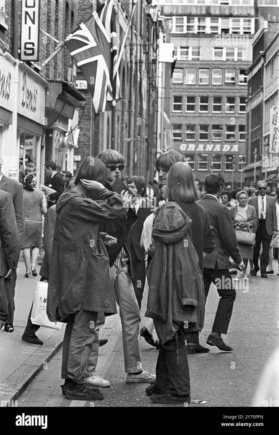 Le centre de la mode londonien pour les plus jeunes est Carnaby Street, la rue la plus connue, sinon la plus populaire de Londres. Les jeunes aux cheveux longs parlent loin les heures à Carnaby Street la Mecque des modes mod de la capitale anglaise tout au long de la mini-jupes aux derniers styles en vestes et pantalons pour hommes peut être acheté à Carnaby Street, la mode des jeunes HQ20 juillet 1967 Banque D'Images