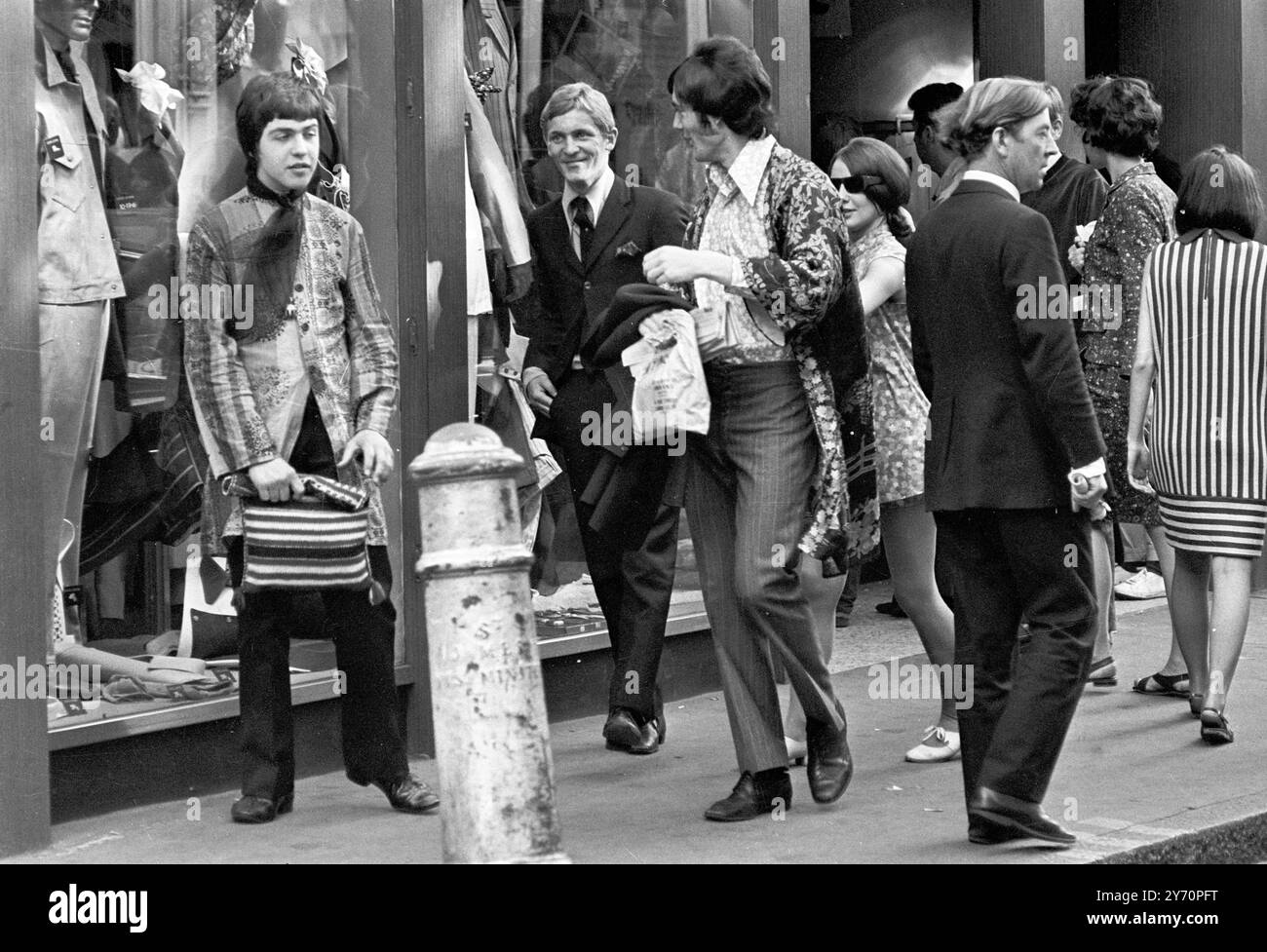Le centre de la mode londonien pour les plus jeunes est Carnaby Street, la rue la plus connue, sinon la plus populaire de Londres. Les jeunes aux cheveux longs parlent loin les heures à Carnaby Street la Mecque des modes mod de la capitale anglaise tout au long de la mini-jupes aux derniers styles en vestes et pantalons pour hommes peut être acheté à Carnaby Street, la mode des jeunes HQ20 juillet 1967 Banque D'Images