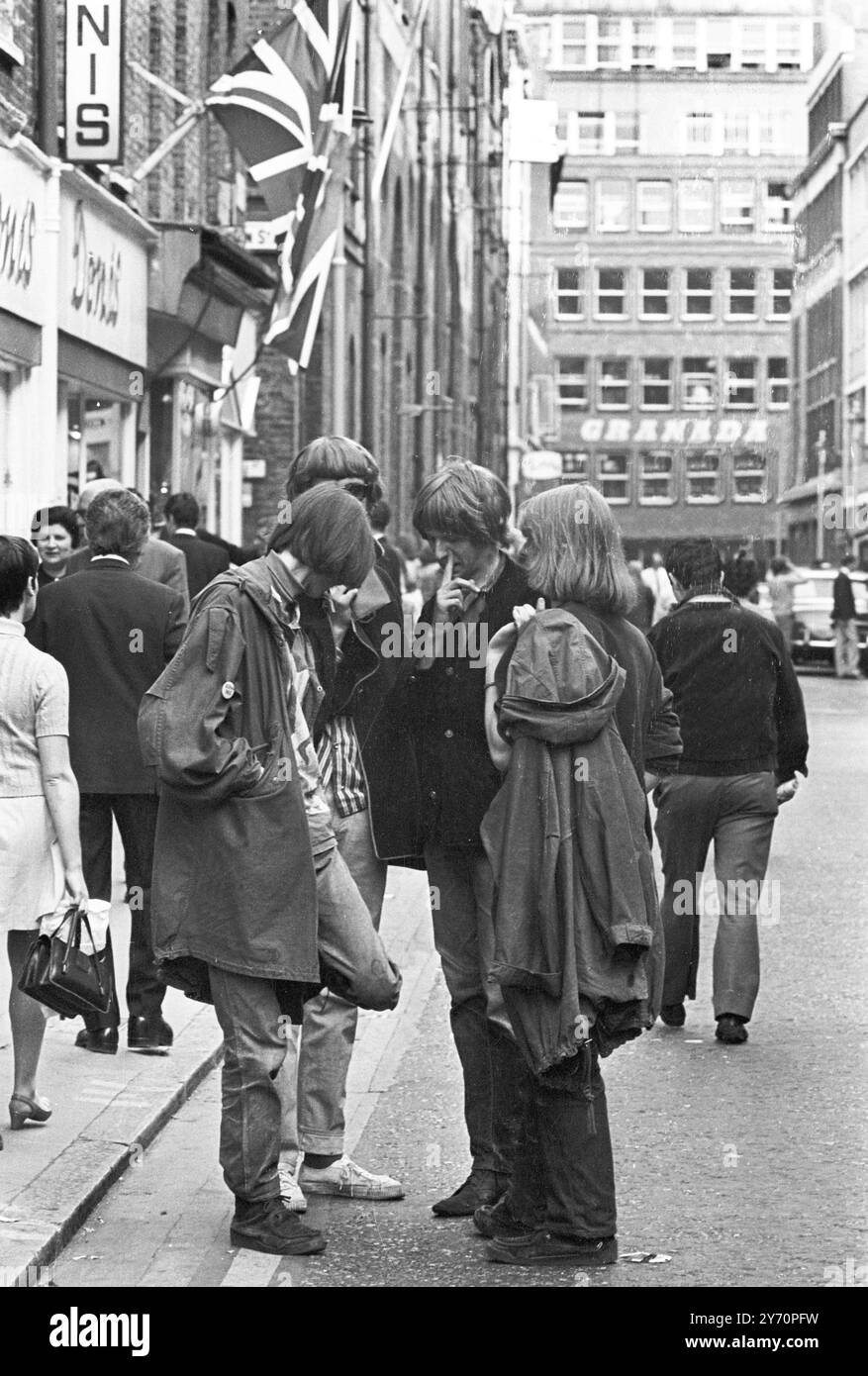 Le centre de la mode londonien pour les plus jeunes est Carnaby Street, la rue la plus connue, sinon la plus populaire de Londres. Les jeunes aux cheveux longs parlent loin les heures à Carnaby Street la Mecque des modes mod de la capitale anglaise tout au long de la mini-jupes aux derniers styles en vestes et pantalons pour hommes peut être acheté à Carnaby Street, la mode des jeunes HQ20 juillet 1967 Banque D'Images