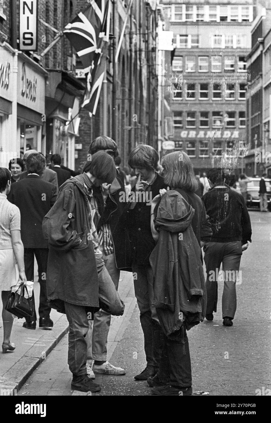 Le centre de la mode londonien pour les plus jeunes est Carnaby Street, la rue la plus connue, sinon la plus populaire de Londres. Les jeunes aux cheveux longs parlent loin les heures à Carnaby Street la Mecque des modes mod de la capitale anglaise tout au long de la mini-jupes aux derniers styles en vestes et pantalons pour hommes peut être acheté à Carnaby Street, la mode des jeunes HQ20 juillet 1967 Banque D'Images