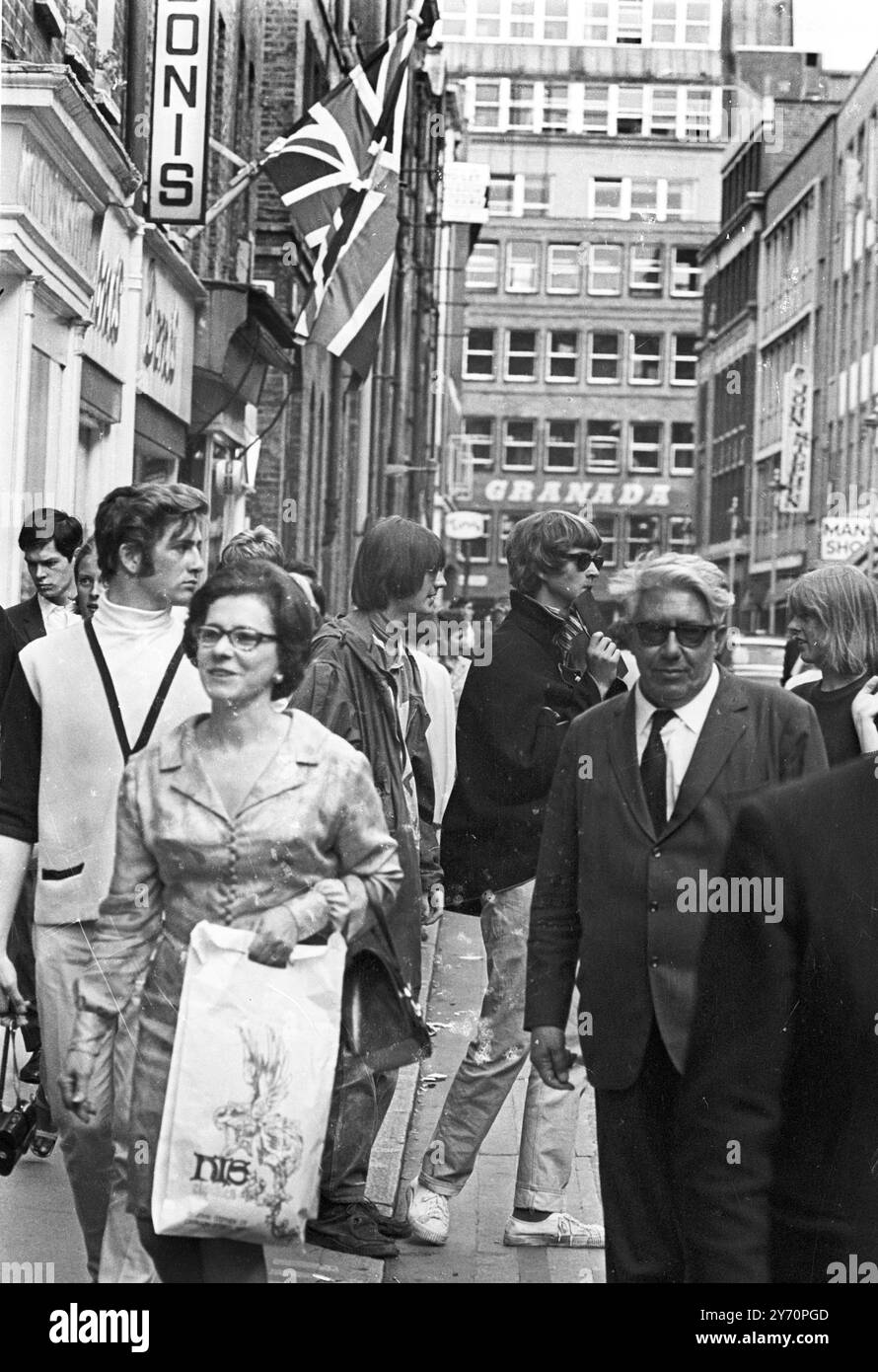Le centre de la mode londonien pour les plus jeunes est Carnaby Street, la rue la plus connue, sinon la plus populaire de Londres. Les jeunes aux cheveux longs parlent loin les heures à Carnaby Street la Mecque des modes mod de la capitale anglaise tout au long de la mini-jupes aux derniers styles en vestes et pantalons pour hommes peut être acheté à Carnaby Street, la mode des jeunes HQ20 juillet 1967 Banque D'Images