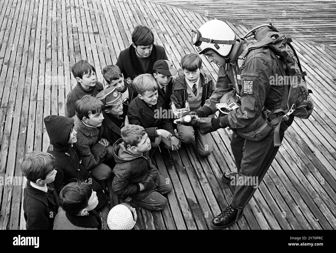 SKYMAN TOMBE EN ............ BRIGHTON ; Un groupe d'écoliers attentifs regardent le caporal Brian David de la célèbre équipe de parachutisme en chute libre des 'Red Devils' du Parachute Regiment, démontrer les astuces de son commerce avec un jouet d'action Man Red Devil. C'est la dernière ligne de poupée pour garçons fantastiquement réussie, qui peut être obtenue avec une série de tenues et d'uniformes authentiques. Il s'est rendu à Brighton pour expliquer l'équipement avec la poupée aux jeunes qui assistent à l'ouverture de la foire du jouet de Brighton aujourd'hui. 28 janvier 1968 Banque D'Images