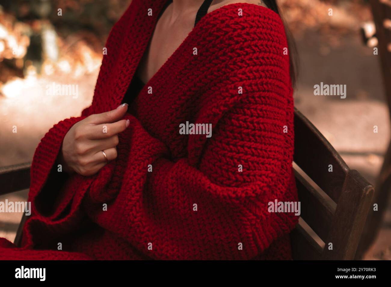 Cardigan pull chaud rouge tricoté confortable sur le corps des femmes, vêtements d'extérieur d'automne Banque D'Images