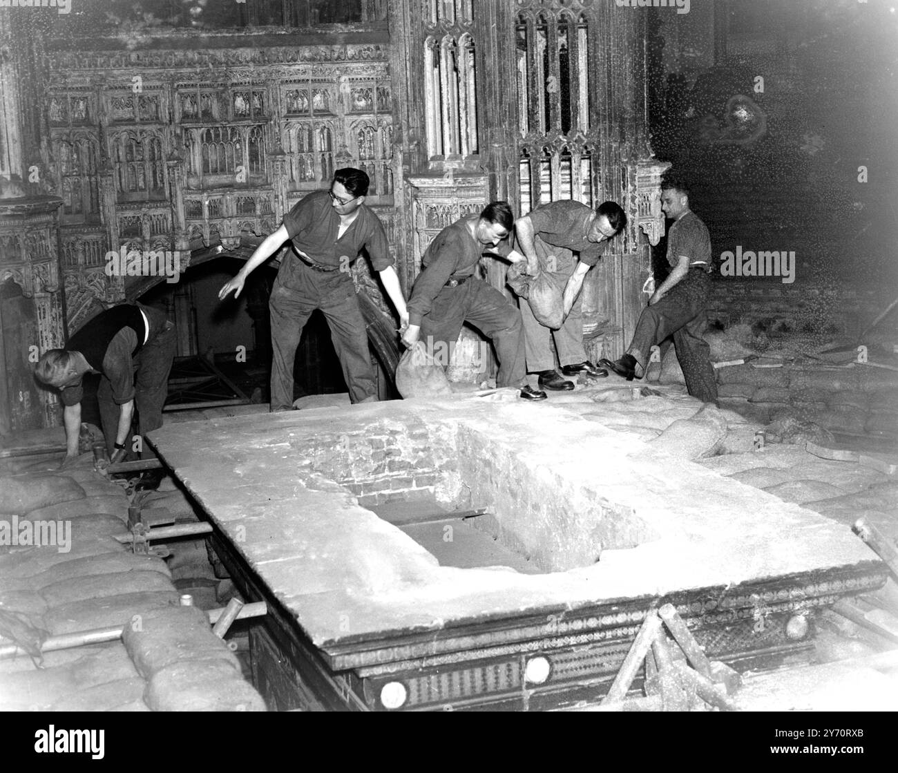 Les travaux ont commencé sur l'enlèvement de 80 000 sacs de sable qui protégeaient les monuments précieux de l'abbaye de Westminster , Londres , Angleterre , et on espère que dans un an l'abbaye sera restaurée à son ancienne gloire . Les dégâts des raids aériens sont estimés à £135 000 mais des précautions efficaces contre l'action ennemie ont sauvé chaque caractéristique d'intérêt historique. Le vitrail le plus ancien a été enlevé au début de la guerre , et le reste n'a pas été très endommagé . Cinq des maisons de l'abbaye ont été détruites ou gravement endommagées ; ils comprennent la maison du doyen , les cloîtres et les petits cloîtres , et les bâtiments de W. Banque D'Images