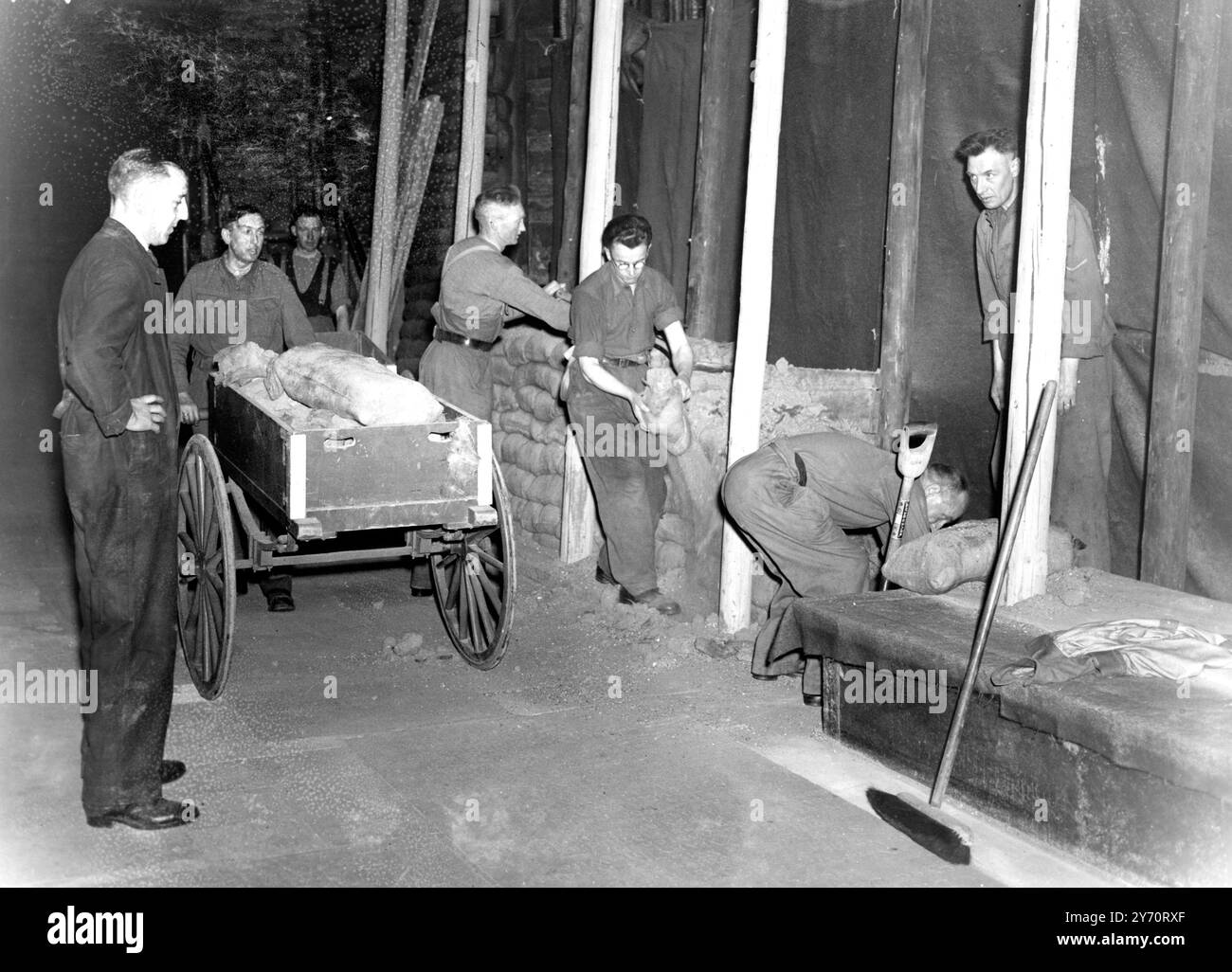 Les travaux ont commencé sur l'enlèvement de 80 000 sacs de sable qui protégeaient les monuments précieux de l'abbaye de Westminster , Londres , Angleterre , et on espère que dans un an l'abbaye sera restaurée à son ancienne gloire . Les dégâts des raids aériens sont estimés à £135 000 mais des précautions efficaces contre l'action ennemie ont sauvé chaque caractéristique d'intérêt historique. Le vitrail le plus ancien a été enlevé au début de la guerre , et le reste n'a pas été très endommagé . Cinq des maisons de l'abbaye ont été détruites ou gravement endommagées ; ils comprennent la maison du doyen , les cloîtres et les petits cloîtres , et les bâtiments de W. Banque D'Images