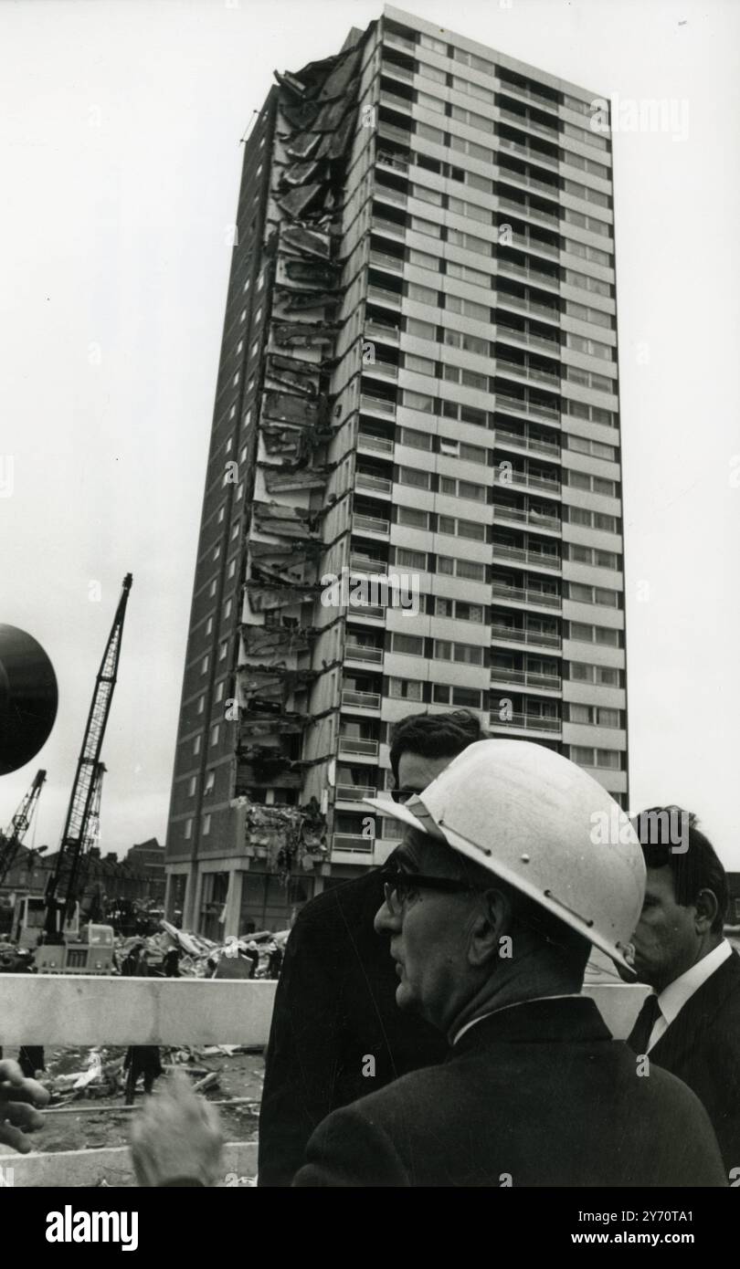 M. Alfred Silver ( portant un casque de protection ) agent de sécurité à l'ingénieur d'arrondissement du Conseil de Newham , parle aux fonctionnaires sur les lieux de l'effondrement désastreux de l'appartement de ce matin à Custom House , East London . L'effondrement d'une partie du bloc de 23 étages récemment achevé s'est produit peu après 6 heures aujourd'hui . Les chiffres les plus récents sont de trois morts, neuf blessés et sept disparus. Le bloc de la tour est également connu sous le nom de Ronan point , nommé d'après le maire adjoint Harry Ronan ( un ancien président du Comité du logement du quartier londonien de Newham ) , Londres , Angleterre . 16 mai 1968 Banque D'Images