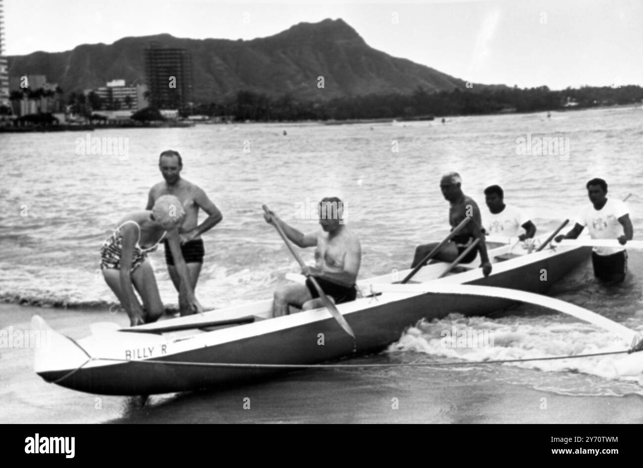 Earl Mountbatten de Birmanie ( tenant le pagaie à gauche ) le chef d'état-major de la Défense de Grande-Bretagne , reçoit des instructions d'expert sur le pagayage d'un canoë-balancier de son vieil ami , le duc Kahanamoku ( assis sur le côté de l'embarcation ) le champion olympique . Plus tard Lord Mountbatten avec sa fille, Lady Patricia Bradbourne (à gauche) est allé faire du surf dans le canoë de la plage de Waikiki . Père et fille sont arrivés ici il y a une semaine pour des conférences entre le comte et les commandants militaires américains postés ici. Le sujet principal était la politique anglo-américaine dans le Pacifique et l'Asie du Sud-est . Lord Mountbatten et Lady Banque D'Images