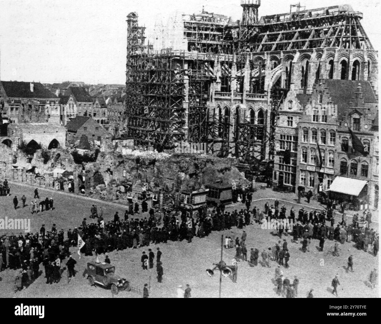 La défense immortelle d'Ypres saillant : le mémorial de la porte de Menin , symbole de courage et d'endurance . En passant par les ruines de la salle des étoffes (à gauche) et la cathédrale reconstruite : ' pèlerins ' à Ypres en route pour le dévoilement du mémorial de la porte de Menin . 24 juillet 1927 Banque D'Images