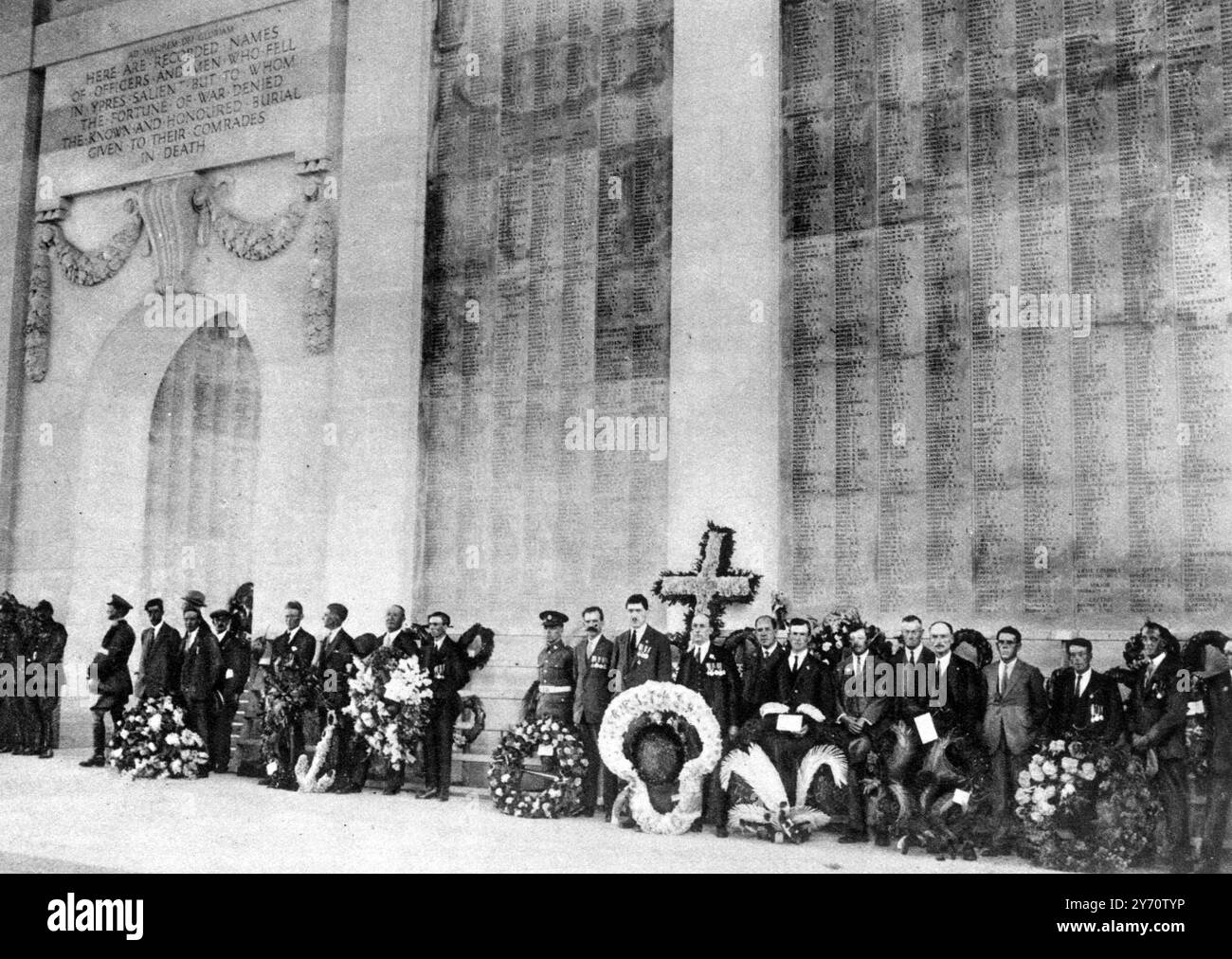 La défense immortelle d'Ypres saillant : le mémorial de la porte de Menin , symbole de courage et d'endurance . ' Voici les noms enregistrés des officiers et des hommes qui sont tombés à Ypres saillant , mais auxquels la fortune de la guerre a nié le cimetière connu et honoré donné à leurs camarades dans la mort ' : ex-militaires avec leurs couronnes sous l'arc du mémorial , dont les murs portent les noms des disparus . 24 juillet 1927 Banque D'Images