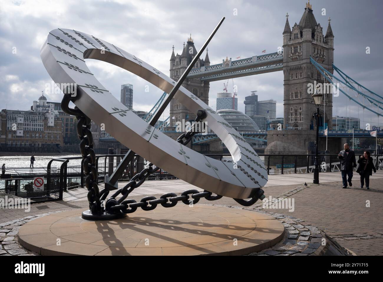 Avec le Tower Bridge de Londres en arrière-plan, se trouve la sculpture céleste intitulée «garde-temps», le cadran solaire équinoctial conçu par Wendy Taylor et commandé par Strand Hotels Limited en mars 1973, le 24 septembre 2024, à Londres, en Angleterre. Un cadran solaire équinoctial de base moderne est aligné sur le plan de l'Équateur. Banque D'Images