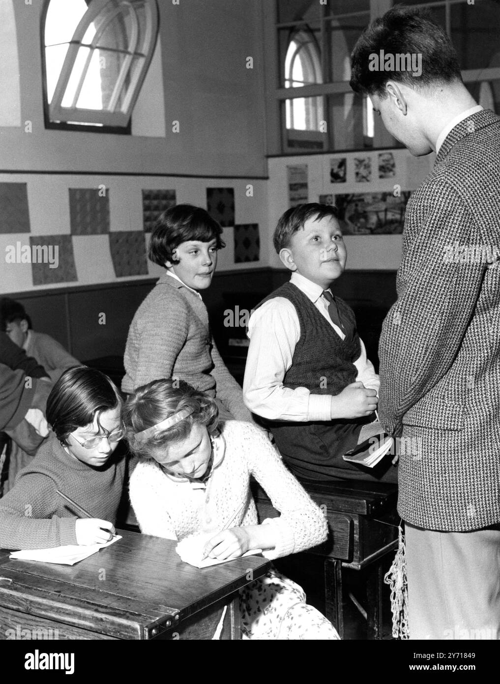 L'école primaire du comté de Northfleet a invité le journaliste Hugh Witt à leur donner une conférence sur la production de journaux , et voici M. Witt qui parle à quatre des rédacteurs des journaux scolaires , Kent , Angleterre . 11 avril 1960 Banque D'Images