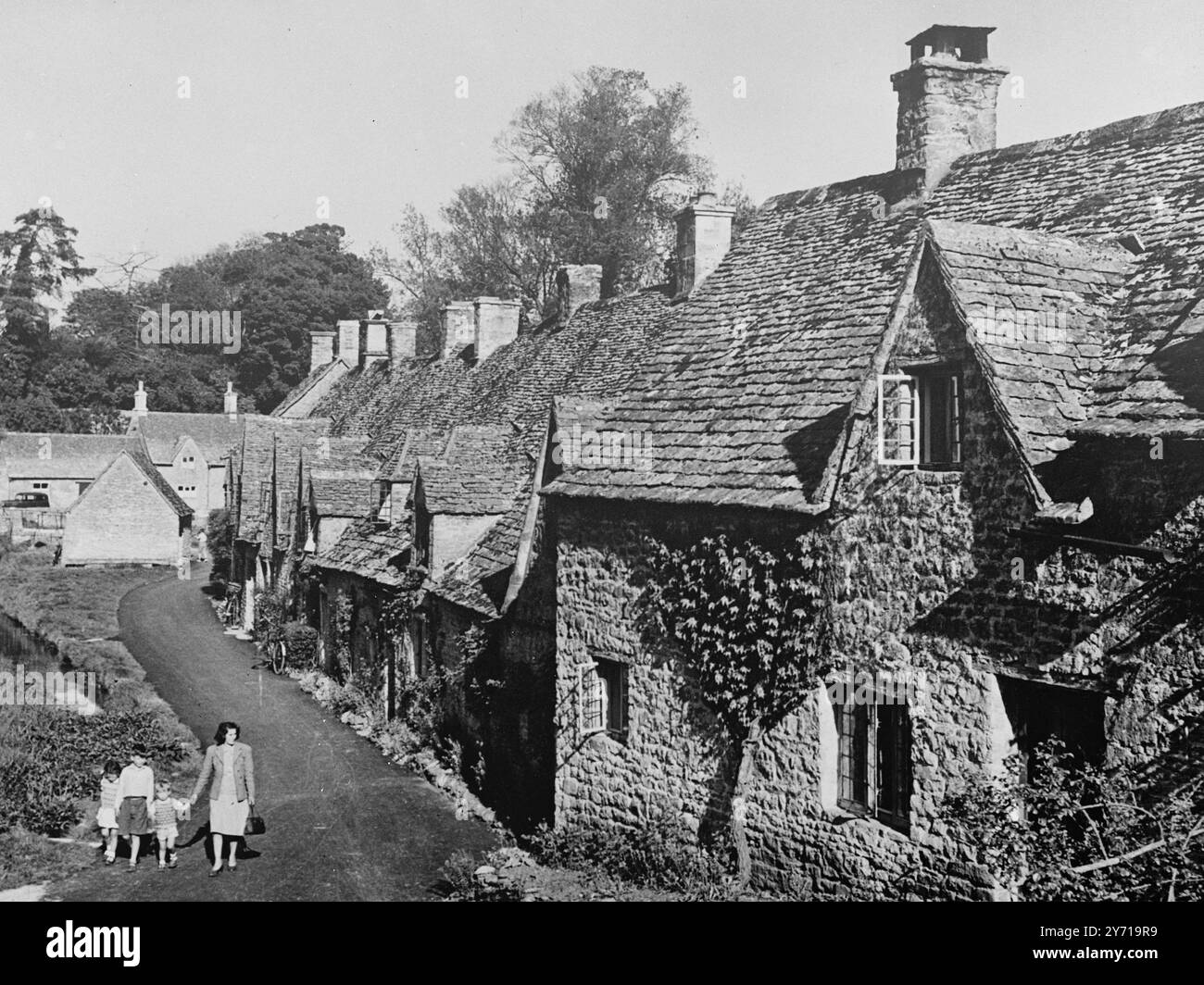 BEAUTY SPOT FOR NATIONAL TRUST Arlington Row , Bibury , Gloucestershire , une rangée de huit chalets typiques des Cotswold , est en cours de remise au National Trust par le Bristol and Gloucestershire Archaeological Trust . Les chalets sont construits en pierre locale , avec une pente raide - inclinée . pierre - toits en ardoise et pignons pointus. Ils datent de la fin du 16 ème et du début du 17ème siècle. Le National Trust a reçu une subvention du Pilgrim Trust pour couvrir le coût des réparations essentielles. Les locataires actuels continueront à vivre dans les chalets. 7 mars 1949 Banque D'Images