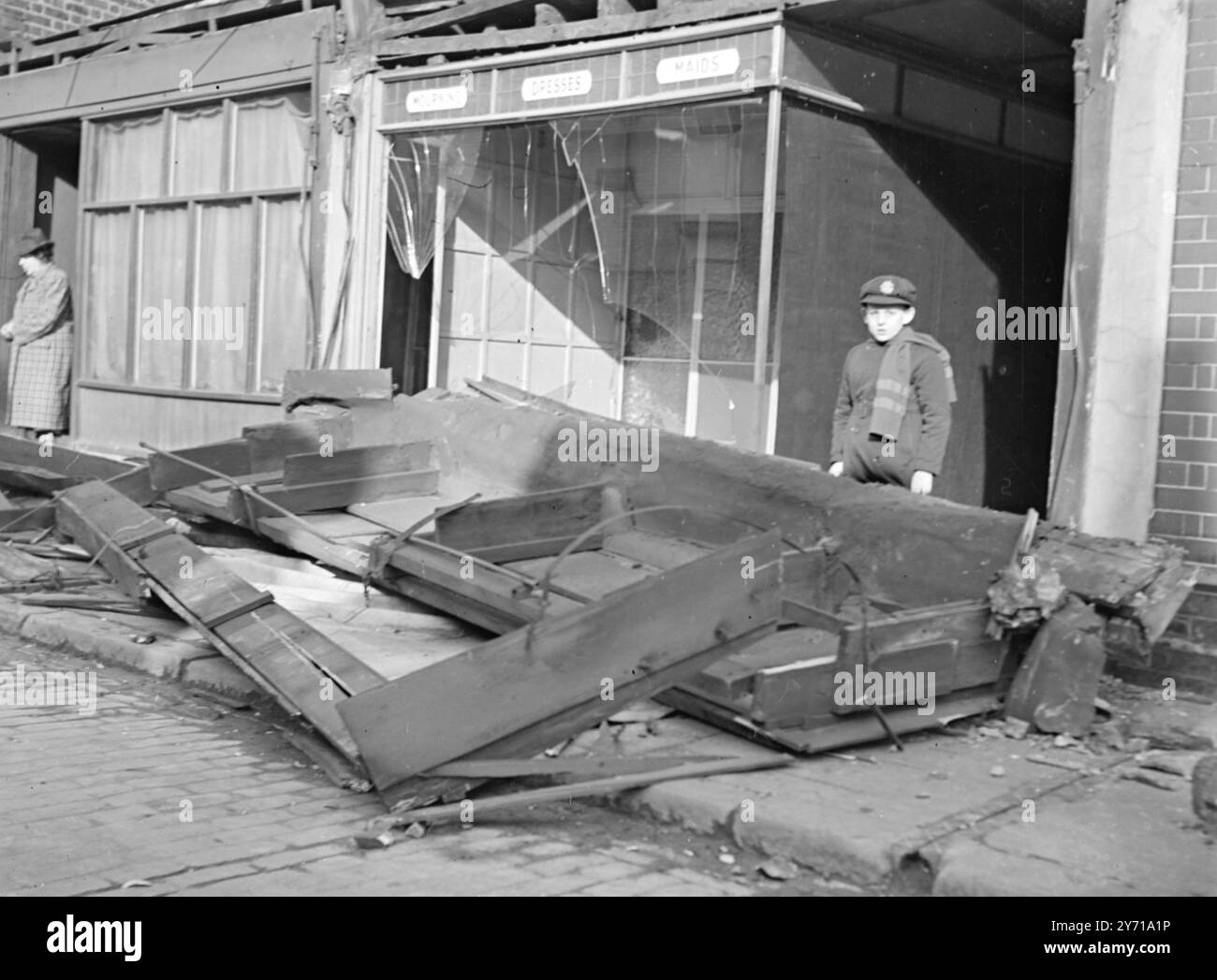 STRATFORD APRÈS COUP, les vents de mars sont arrivés deux jours plus tôt et ont causé un grand coup à un commerçant à Angel Lane , une rue de marché sur Stratford , Londres , à la mi-journée aujourd'hui. Le coup de vent a fait exploser une section au-dessus de la boutique et a fait des ravages avec la fenêtre . 27 février 1949 Banque D'Images