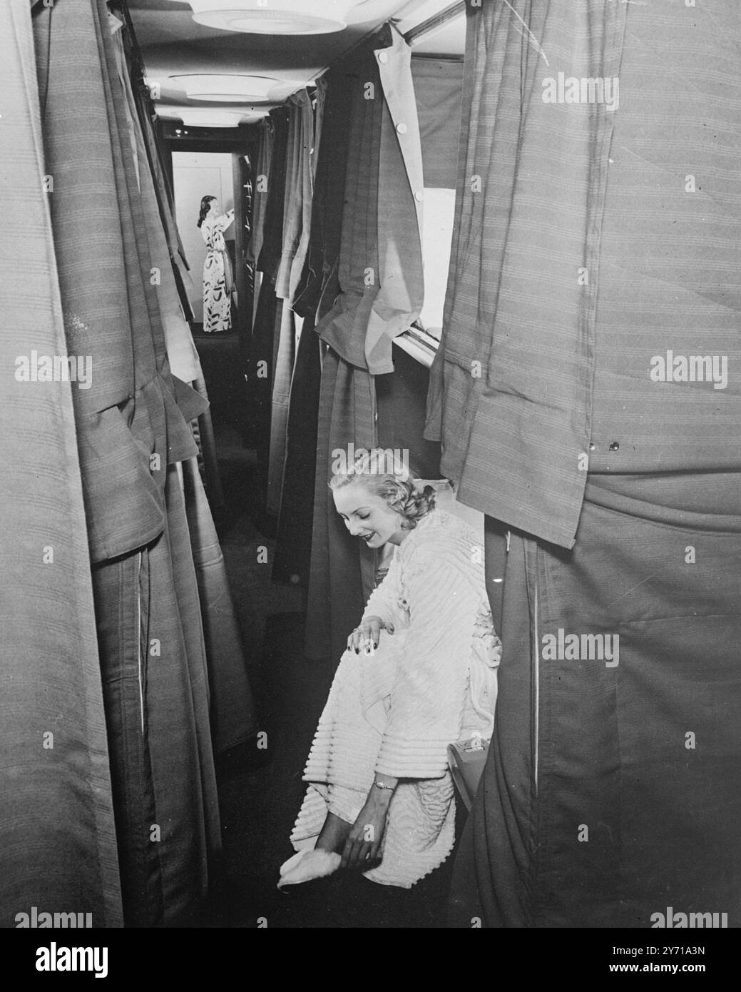 SKY SLEEPER a compensé pour un vol de nuit à Londres, Pan American Airways nouveau Clipper '' America '' classe Stratocruiser maintanace son sentiment de luxe . Regardant vers l'avant depuis la porte d'entrée. au milieu de la cabine, les sièges doubles des deux côtés de la large allée ont été transformés en couchettes comfatables de plus de - taille. Couchettes supérieures , mesurant six pieds 3 et demi pouces par 40 pouces , se replient vers le bas des murs supérieurs et comtain tous les rideaux et la literie pour les deux couchettes dans la section couchettes inférieures , assez grandes pour deux personnes , sont six pieds , quatre pouces par 42 pouces . Clipper '' Amérique '' fera son affaire Banque D'Images