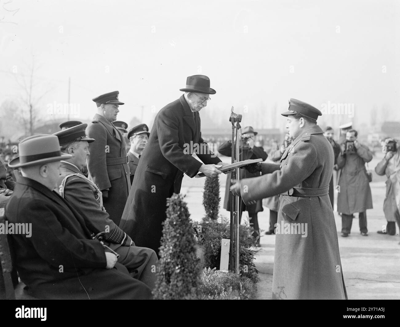 MARIAGE DES COMBATTANTS CÉRÉMONIE DE LA ROYAL AIR FORCE a R.A.F. Station , Tangmere ( Sussex ) une cérémonie a eu lieu qui a abouti à la réforme du NO . 43 Fighter Squadron et la liaison du No . Escadron 245 et 266 - qui ont tous deux joué un rôle inestimable dans les opérations aériennes pendant la guerre. Non . Le 43e Escadron a pris une part importante à la bataille d'Angleterre dans laquelle il a combattu avec distinction. IMAGES :- SIR JOHN WADDINGTON , G.B.E. , K.C.M.G., H.C.V.O., gouverneur de la Rhodésie du Nord de 1941 à 1947 , présentant un bouclier de défi cadeau au chef d'escadron E. WOOTTEN , D.F.C. - Banque D'Images