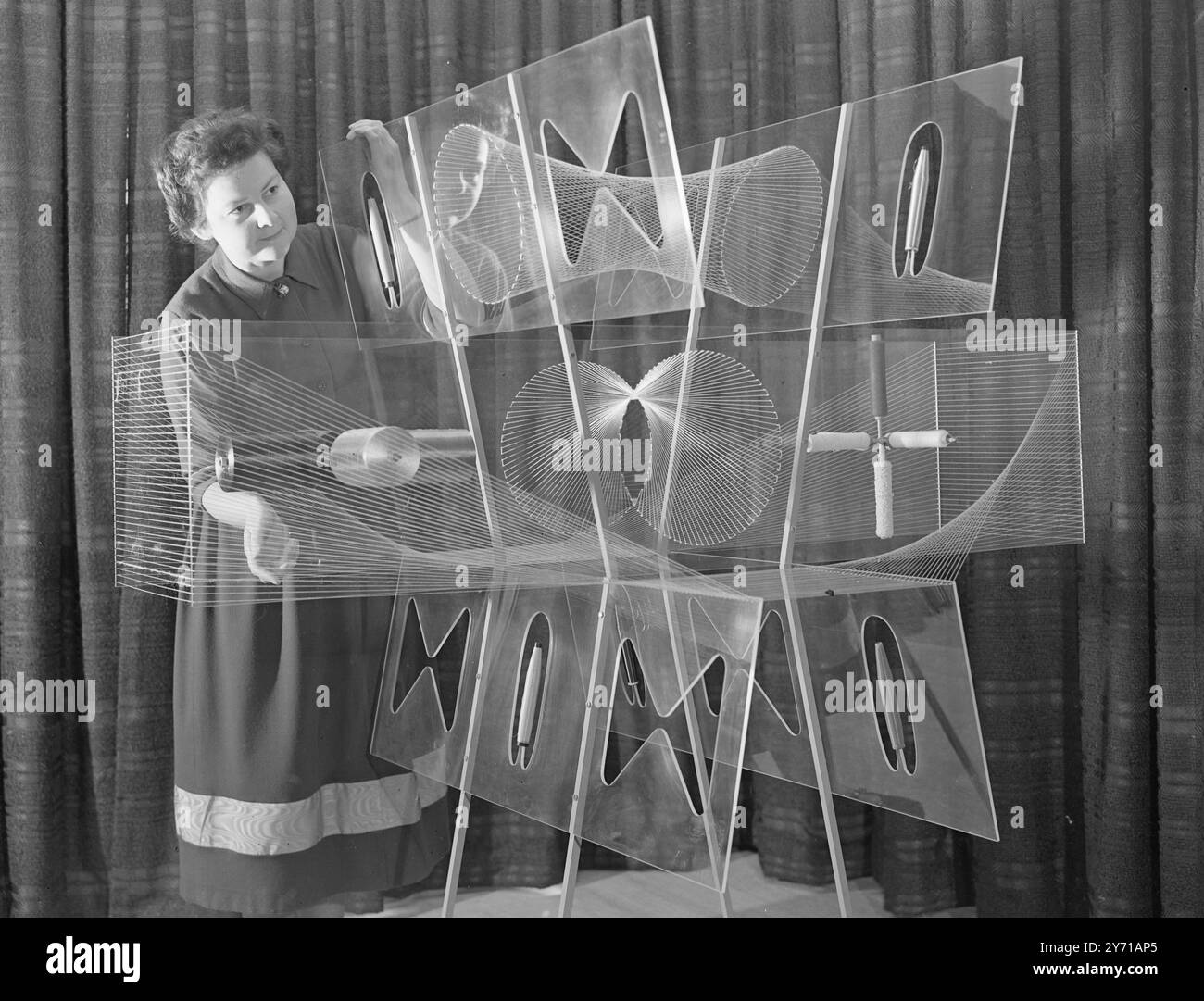 L'INDUSTRIE BRITANNIQUE DE LA RAYONNE EST '' VITRINE MONDIALE '' - - - - Une vitrine mondiale pour l'industrie britannique de la rayonne a vu le jour officiellement lorsque M. Harold Wilson, président de la Chambre de commerce , a ouvert le rayon Industry Design Centre à Upper Grosvenor Street , Londres . Sur l'affichage sont les derniers développements dans l'industrie pour l'inspection des acheteurs d'outre-mer. Les femmes britanniques accueilleront également le défilé du rayon. Il est tellement plus fort que d'autres matériaux ainsi que moins cher. - - - - IMAGES MONTRANT:- '' POUVEZ-VOUS DEVINER? '' - - Miss MARY ADAMS de Bristol , affichant un cubiste saisissant des Banque D'Images