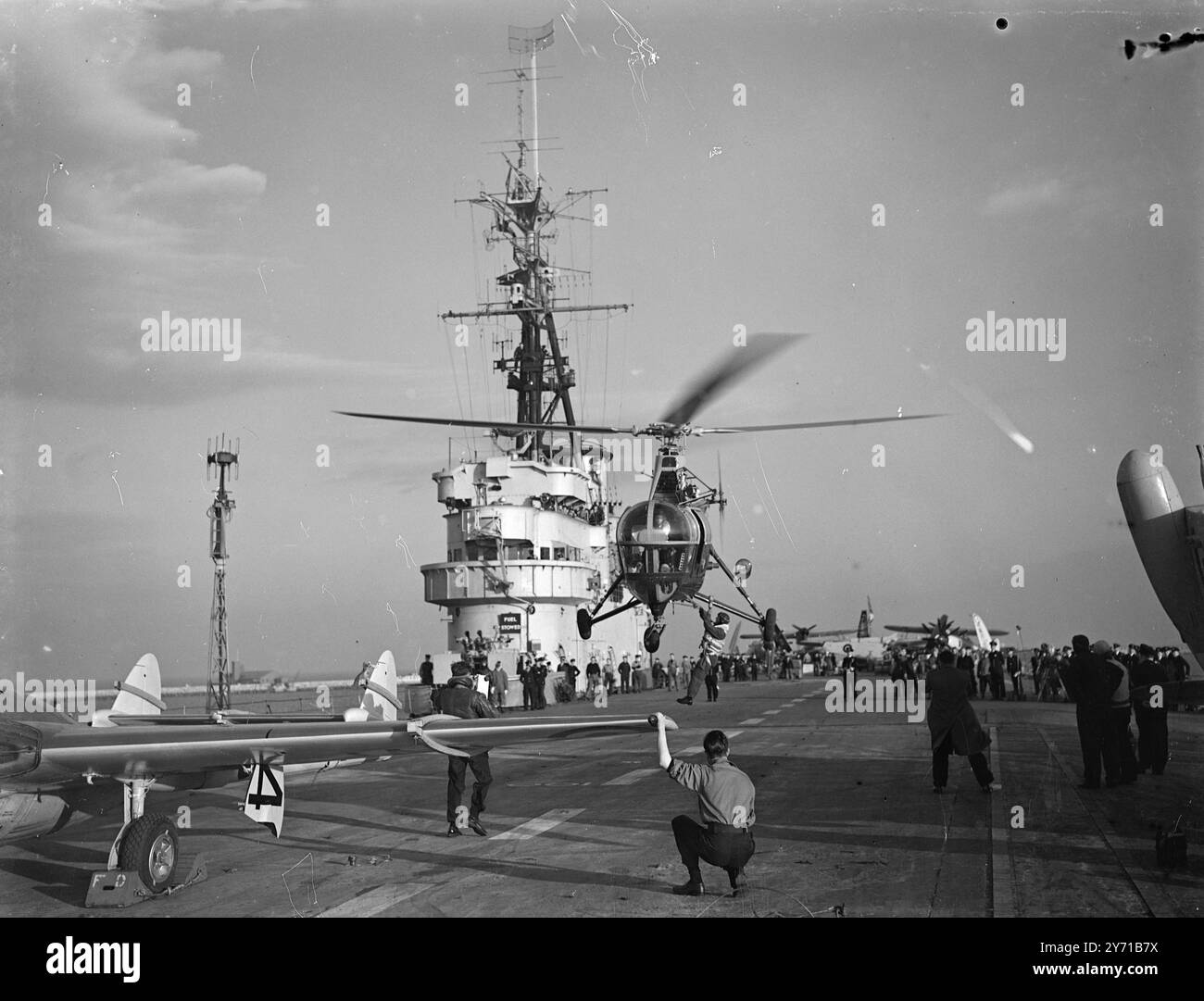 H.M.S. VENGEANCE PRÉPARE LE VOYAGE DANS L'ARCTIQUE le porte-avions de la flotte légère H.M.S. Vengeance de 14 000 tonnes quittera le port de Portland vendredi pour une croisière expérimentale dans l'Arctique. Le but de cette croisière est de tester des vêtements spéciaux pour temps froid , y compris des combinaisons chauffées électriquement . Avant que la Home Fleet ne quitte Portland hier pour sa croisière de printemps , le Vengeance a donné à l'amiral Sir Rhoderick McGrigor , C - DANS C - Home Fleet , une démonstration de l'utilisation d'avions stationnaires pour transporter des officiers d'état-major ou dépêchés de navire à navire . PHOTO MONTRE -Un hélicoptère Sikorsky donnant un dem Banque D'Images H.M.S. VENGEANCE PRÉPARE LE VOYAGE DANS L'ARCTIQUE le porte-avions de la flotte légère H.M.S. Vengeance de 14 000 tonnes quittera le port de Portland vendredi pour une croisière expérimentale dans l'Arctique. Le but de cette croisière est de tester des vêtements spéciaux pour temps froid , y compris des combinaisons chauffées électriquement . Avant que la Home Fleet ne quitte Portland hier pour sa croisière de printemps , le Vengeance a donné à l'amiral Sir Rhoderick McGrigor , C - DANS C - Home Fleet , une démonstration de l'utilisation d'avions stationnaires pour transporter des officiers d'état-major ou dépêchés de navire à navire . PHOTO MONTRE -Un hélicoptère Sikorsky donnant un dem Banque D'Images