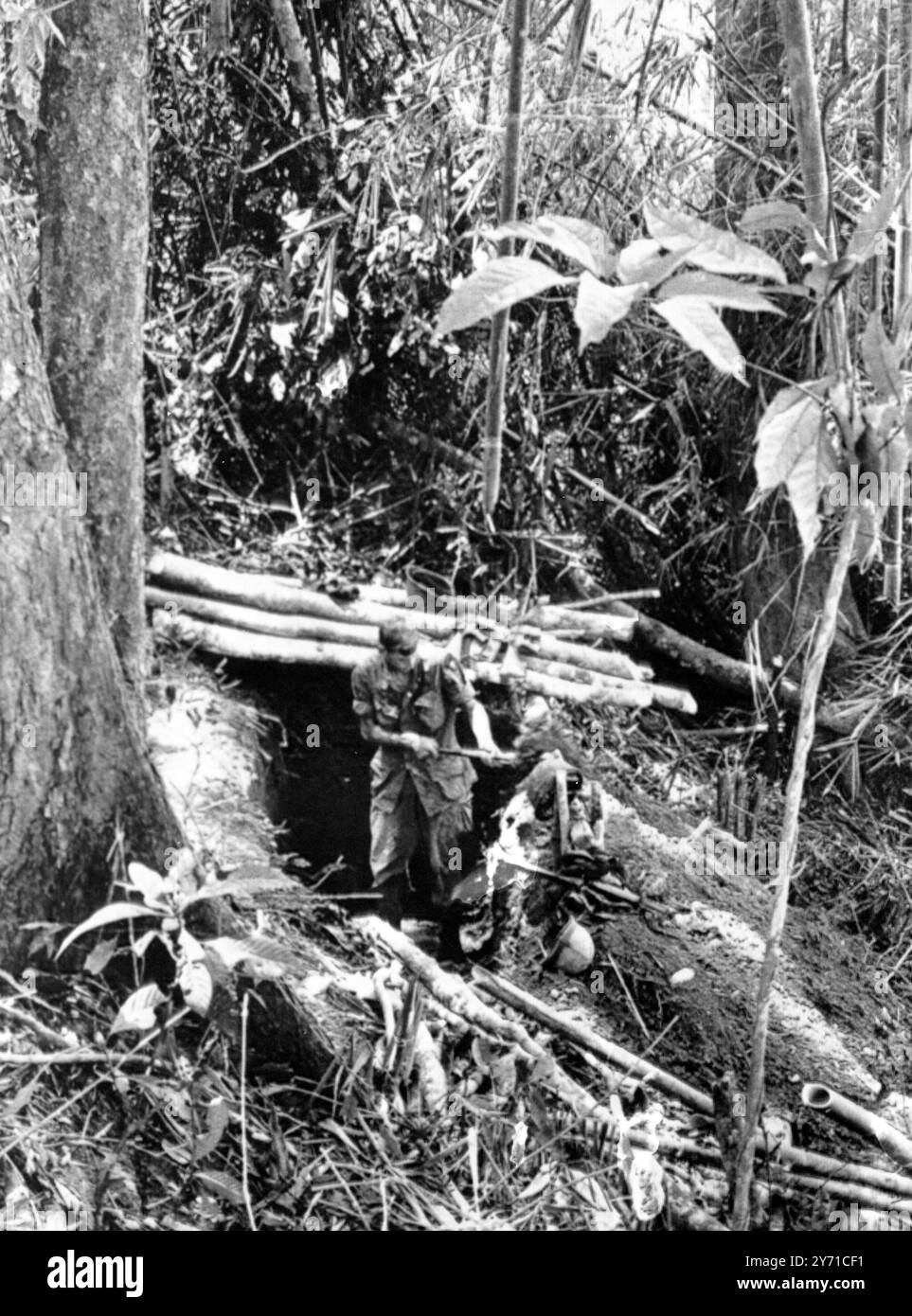 Cherchez et vous verrez un soldat creuser une tranchée dans la forêt dense de la vallée de A Shau à environ un mile à l'est de Loas récemment (17 mai). Il était l'un des soldats qui ont pris part à la récente bataille de 10 jours pour ' Hamburger Hill ' dans laquelle plus de 300 Américains ont été tués ou blessés, Une vallée de Shau, Sud Vietnam . 24 mai 1969 Banque D'Images