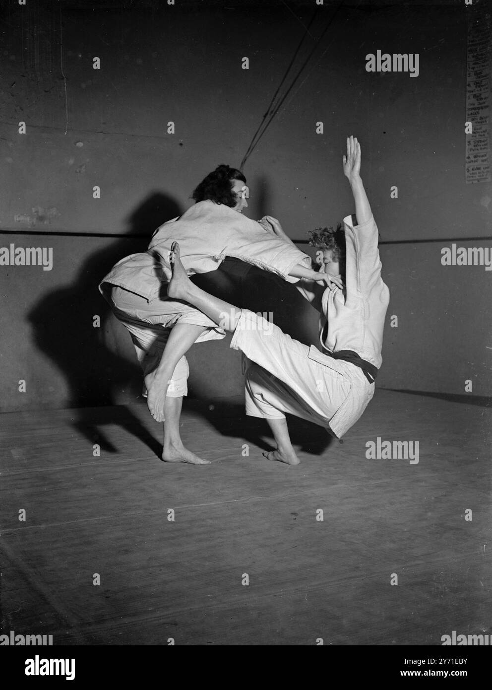 ATTAQUANTS MÉFIEZ-VOUS ! Le judo Wresting - Science japonaise de l'autodéfense - est en train de devenir un passe-temps populaire parmi les femmes et les filles d'affaires en Grande-Bretagne . Les nouveaux venus de judo portent des ceintures blanches pendant l'instruction tandis que la compétence de ceux plus habiles dans l'art de différentes teintes , noir étant la plus haute récompense . IMAGES MONTRENT:- le novice IRIS DEHNEL ( du VERT BOIS , LONDRES ) s'attaque à l'experte MARY SMITH ( à droite) qui arbore la ceinture noire convoitée , au siège londonien du mouvement judo . 2 décembre 1948 Banque D'Images