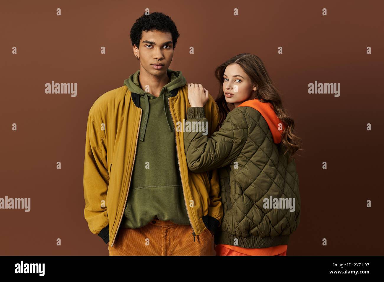 Un jeune couple à la mode présente une tenue d'automne vibrante, dégageant chaleur et style ensemble. Banque D'Images