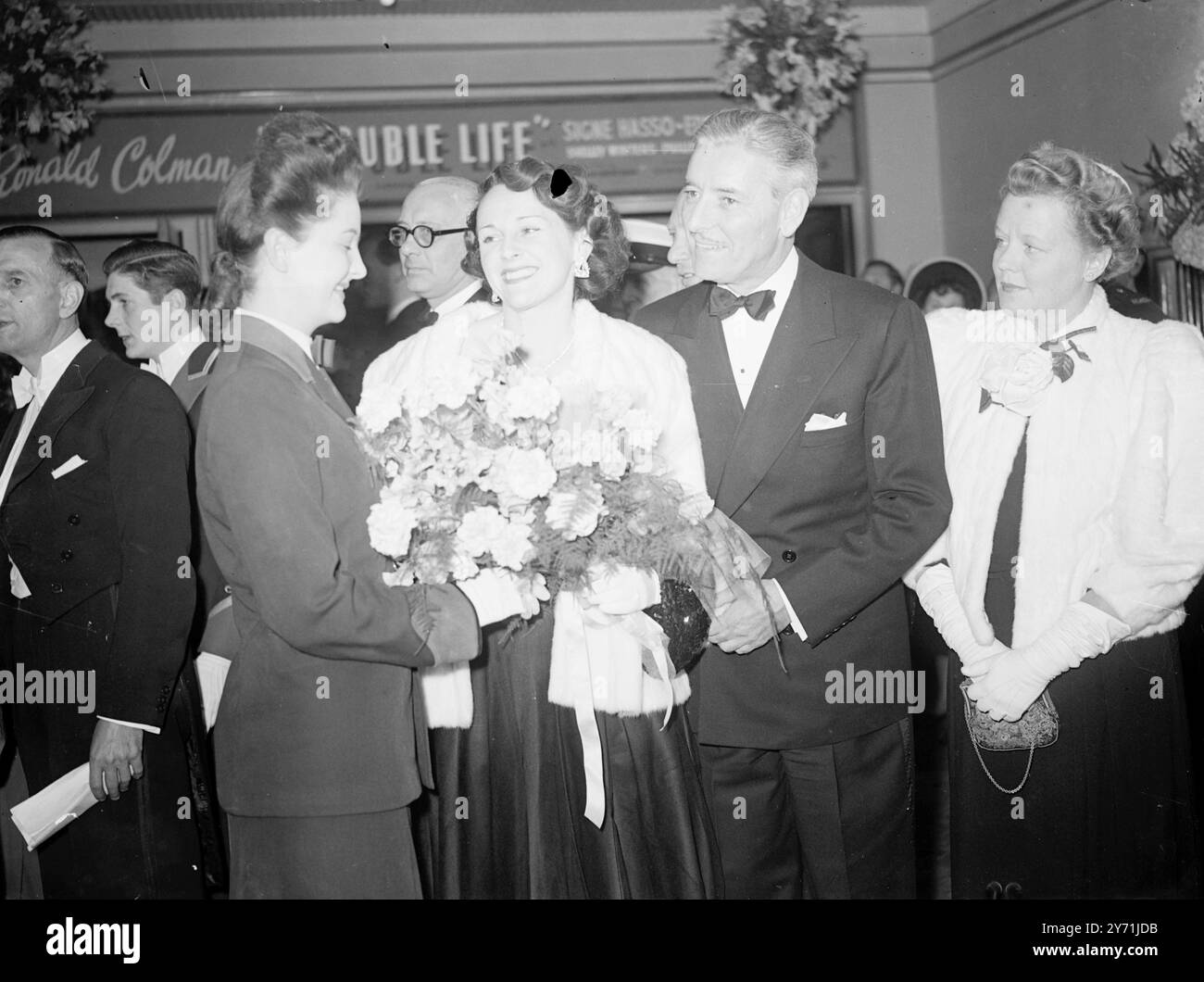 ' A DOUBLE LIFE ' LE LAURÉAT D'UN PRIX DE L'ACADÉMIE ' A double Life ' Est La PREMIÈRE du film lauréat d'un prix de l'Académie ' . A reçu sa première britannique au Leicester Square Theatre , Londres , ce soir , et la star britannique RONALD COLMAN , est rentrée à la maison après 15 ans , pour assister à la représentation. COLMAN , qui joue un acteur obsédé par son rôle Othello , a remporté un Oscar pour son travail dans le film. Il était accompagné de son épouse, BENITA HUME. L'IMAGE MONTRE : - ' vie domestique ' Une MME souriante. COLMAN ( Benita Hume ) tient son bouquet de présentation comme elle est photographiée avec son mari RONALD COLMAN, à Thi Banque D'Images