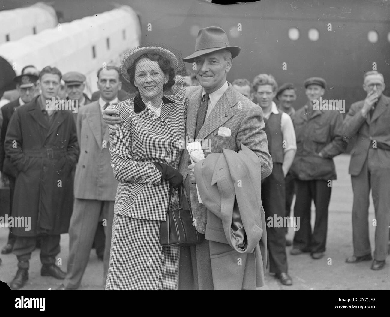 COLMAN RENTRE À LA MAISON le LAURÉAT DES OSCARS ARRIVE d'Hollywood à Southampton, aujourd'hui à bord du paquebot vedette de Cunard-Whit, la REINE ELIZABETH, est la star RONALD COLMAN et son épouse, l'actrice BENITA HUME, qui seront présents ce soir à la première à Londres de ' A DOUBLE LIFE ' , le film Colman ' s Academy Award. PHOTO SHOW:- ' double arrivée ' MR ET MRS. RONALD COLMAN, souriez un bienvenue en Grande-Bretagne, comme ils arrivent à Southampton aujourd'hui. 20 mai 1948 Banque D'Images