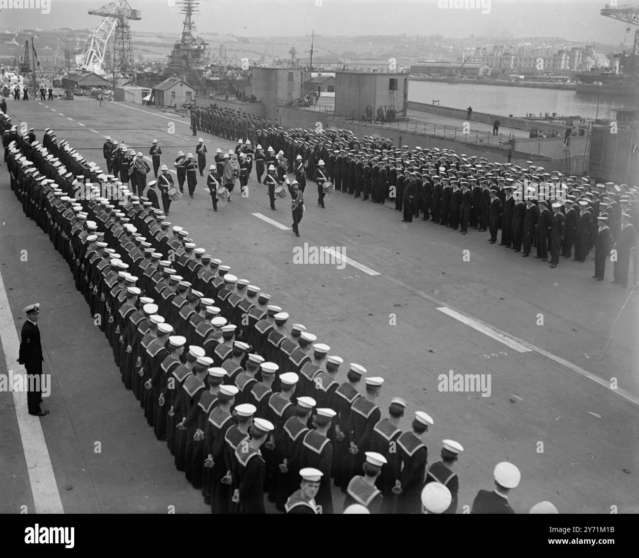 LE PORTE-AVIONS ' VÉNÉRABLE ' VA À LA ROYAL NETHERLANDS NAVY . Une cérémonie a eu lieu à Plymouth , lorsque le porte-avions léger HMS VENERABLE , ( capt M H Evaleigh , R N ) , a été transféré à la Marine royale néerlandaise qui l'a acheté . Le H M S VÉNÉRABLE est achevé en 1945 , et la même année , il fait partie d'une force qui accepte la reddition d'unités de la flotte japonaise à Hong Kong. Son nouveau nom sera le PORTIER KAREL . IMAGE MONTRE :- ' New Dutch Pride ' a bord du PORTIER KAREN ( anciennement , H M S VÉNÉRABLE ) , la bande des Royal Marines passe thro Banque D'Images