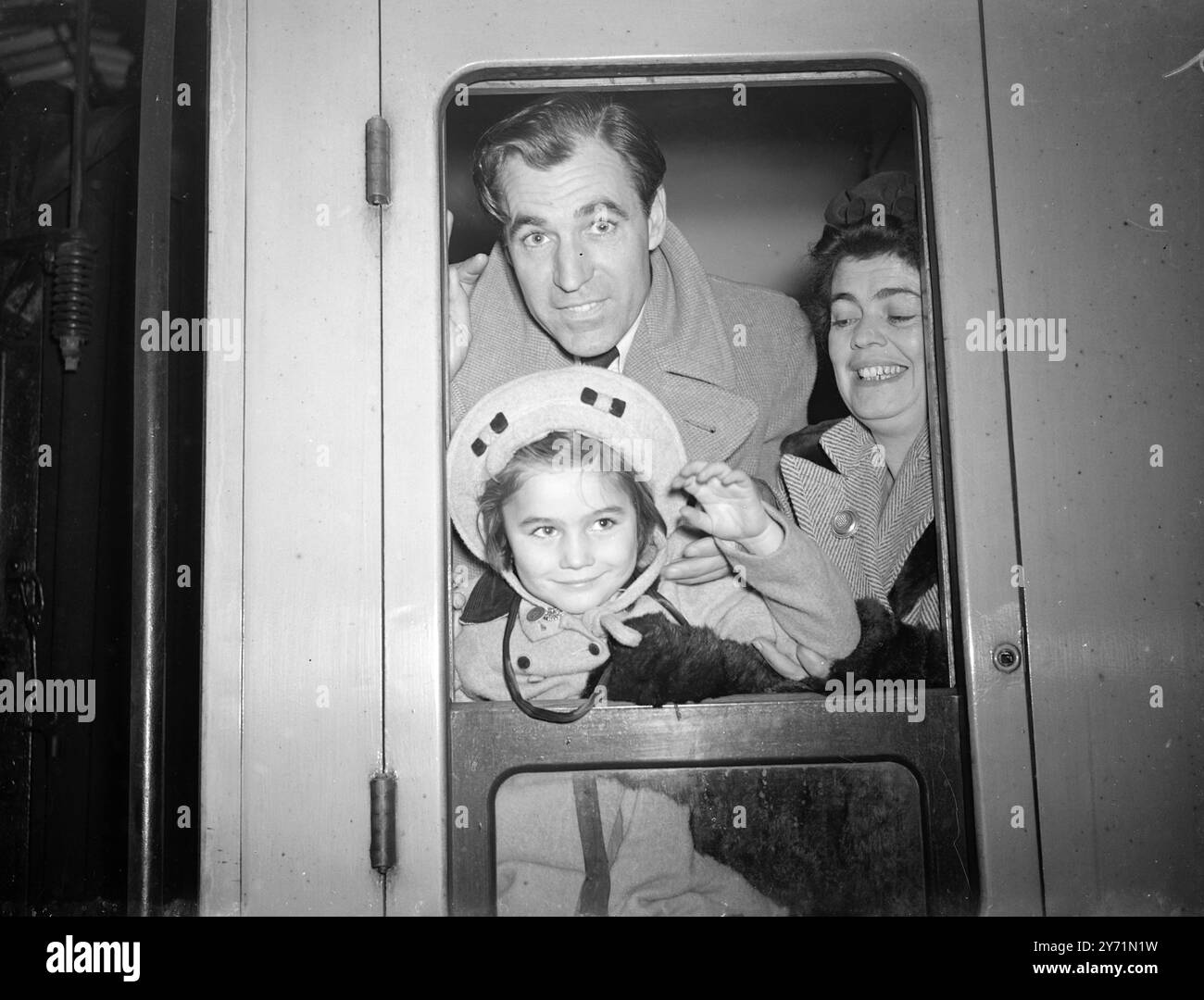 VEDETTES DE CINÉMA D'AFFAIRES AVEC CROISIÈRE DE PLAISANCE British film Star DAVID FARRAR , avec sa femme et son enfant , a quitté la gare de Paddington , Londres , en route pour embarquer à bord du navire BAYANA pour une croisière de plaisance de deux mois aux Bermudes et en Amérique . David alliera affaires et plaisir en faisant plusieurs apparitions personnelles pour son film ''Small Back Room'' actuellement projeté en Amérique. IMAGES MONTRENT:- DAVID FARRAR sa femme et là-bas BARBARA, fille de cinq ans, saluant au revoir alors qu'ils quittaient la gare de Paddington pour Avonmouth, Gloucestershire pour monter à bord du BAYANA. 4 novembre 1948 Banque D'Images