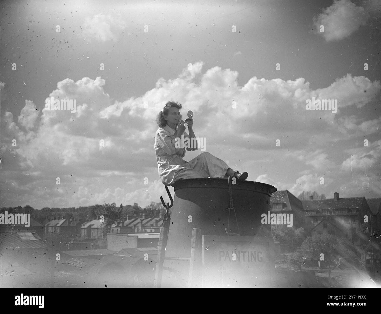 MONTER AU MONDE, Mlle GISELLE LEOPOLD , polonaise aspirant à la gloire en tant que "steeplejill", apporte des nerfs éprouvés à sa nouvelle profession. Avant la guerre, Mlle Leopold était pilote de planeur , et a fait plusieurs sauts en parachute . Maintenant, elle essaie quelque chose de relativement sédatif. Elle est l'une des 1500 personnes qui ont répondu à une publicité d'une entreprise de steeplejacks à Winchmore Hill pour «jeunes hommes bien éduqués» qui sont prêts à enlever leurs manteaux et apprendre un métier passionnant. IMAGES MONTRENT:- femmes éternelles ! Il a besoin d'une main ferme pour appliquer un rouge à lèvres -surtout au sommet d'un chi Banque D'Images