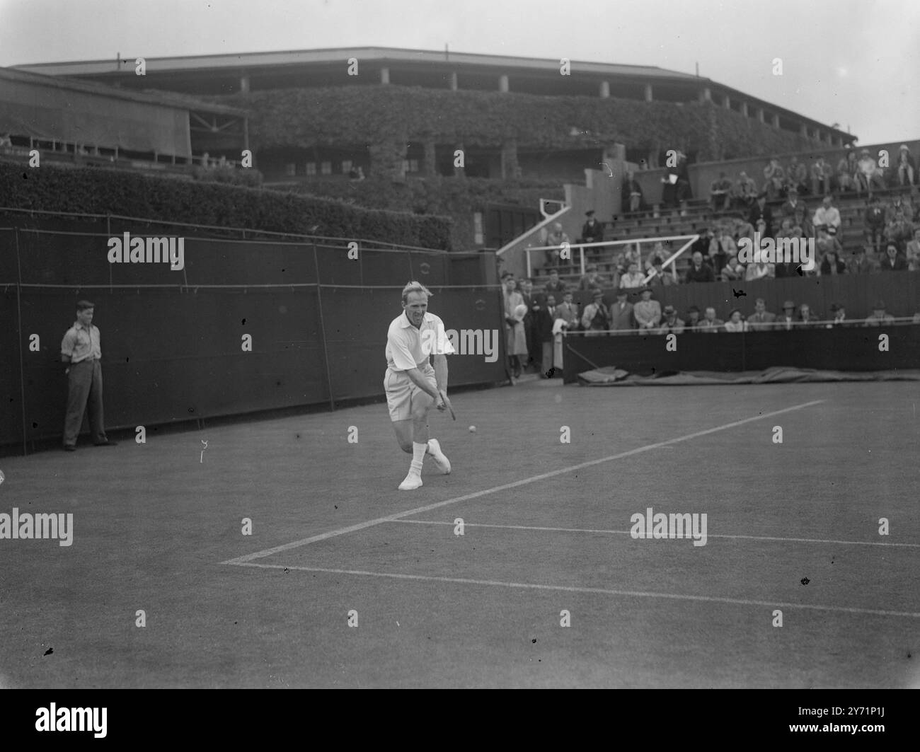 'Aussie Two-Hander' - en simple masculin à Wimbledon J.E. Bromwich , l'un des meilleurs joueurs de tennis australiens, est vu en jeu contre J.van den Eynde , ( Belgique ), dans le championnat masculin de tennis sur gazon de Wimbledon. Bromwich s'est blessé à la jambe récemment et portait un bandage , mais malgré ce handicap , il a réussi à gagner le match . 22 juin 1948 Banque D'Images