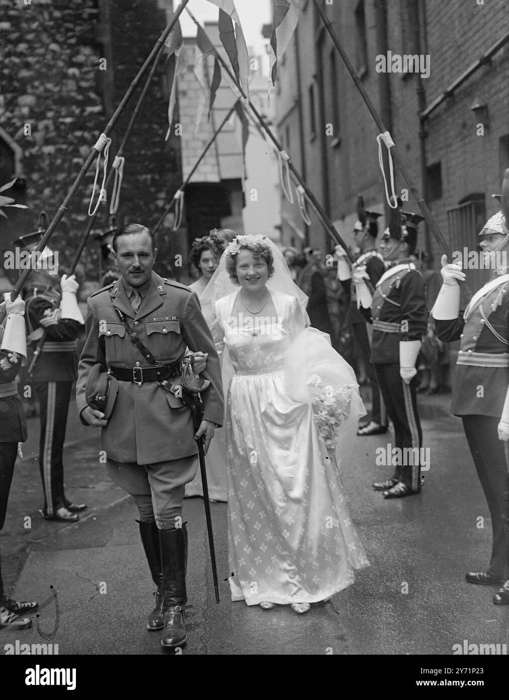 Neveu de Lord Birdwood épouse Miss Betty Scott. Le mariage du major Christopher Birdwood , neveu de 29 ans du maréchal Lord Birdwood , et de Mlle Betty Scott , fille unique du capitaine et de Mme Claud Scott , de Walton Street, Kensington , a eu lieu à Michael's, Chester Square, Londres. Images montrent : ' lancer's bride ' - sous une arche de lances, tenue par une garde d'honneur des sergents du 12e Lancers - le régiment du marié - le pont et le marié quittent Michael's après leur mariage aujourd'hui. La garde d'honneur des lanceurs portait une robe complète pittoresque. 19 juin 1948 Banque D'Images