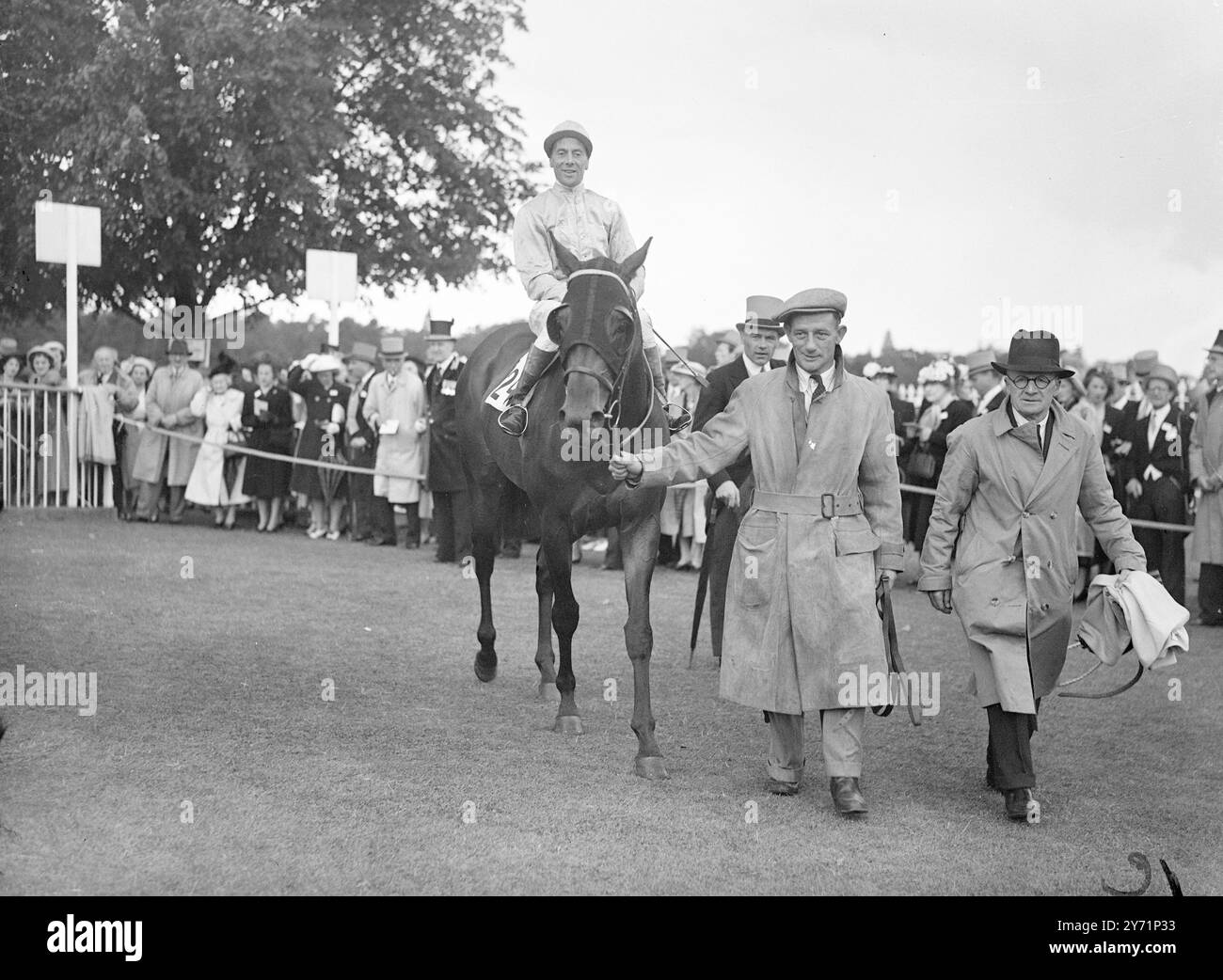 Royal Ascot - la Coca blanche gagne la pioche de Wokingham. La quatrième journée de course du Royal Ascot 1948, a vu M. R.L.Glasspool 'White Cockade', (Sirott Up) remporter les Wokingham Stakes à Ascot aujourd'hui (vendredi). Arrivant en deuxième et troisième place respectivement dans une photo finish, était le «score final» de M. E.B. Baring, (C.. Elliot Up, No 15) et 'Clarion III' de m. R.D.Strassburger, (Smirke Up, No 1). L'image montre: "Leader's load in" - Une 'White Cocade' cagoulée et victorieuse, montée par Jockey Sirett, est menée après sa victoire à Ascot aujourd'hui (vendredi). Banque D'Images