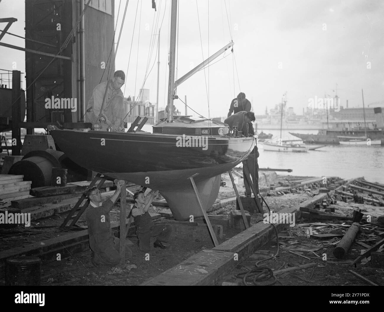 « Ready to buzz » - Royal Racing Yacht Ready. Le «Bluebottle» , le petit yacht de course, qui sera présenté à leurs Altesses Royales, la princesse Elizabeth et le duc d'Édimbourg, est presque achevé à Camper and Nicholson's Yard, Gosport, Hants. L'image montre : 'Royal Racer' - les lignes minces de 'Bluebottle', peut être clairement vu, comme elle approche de l'achèvement sur la cale à Gosport. Le yacht est le cadeau de l'Island Sailing Club, île de Wight, et est dans la classe Dragon. Un des officiers frères du duc, le lieutenant M Crighton, naviguera sur le yacht lors de ses essais. Juin 29 1948 Banque D'Images