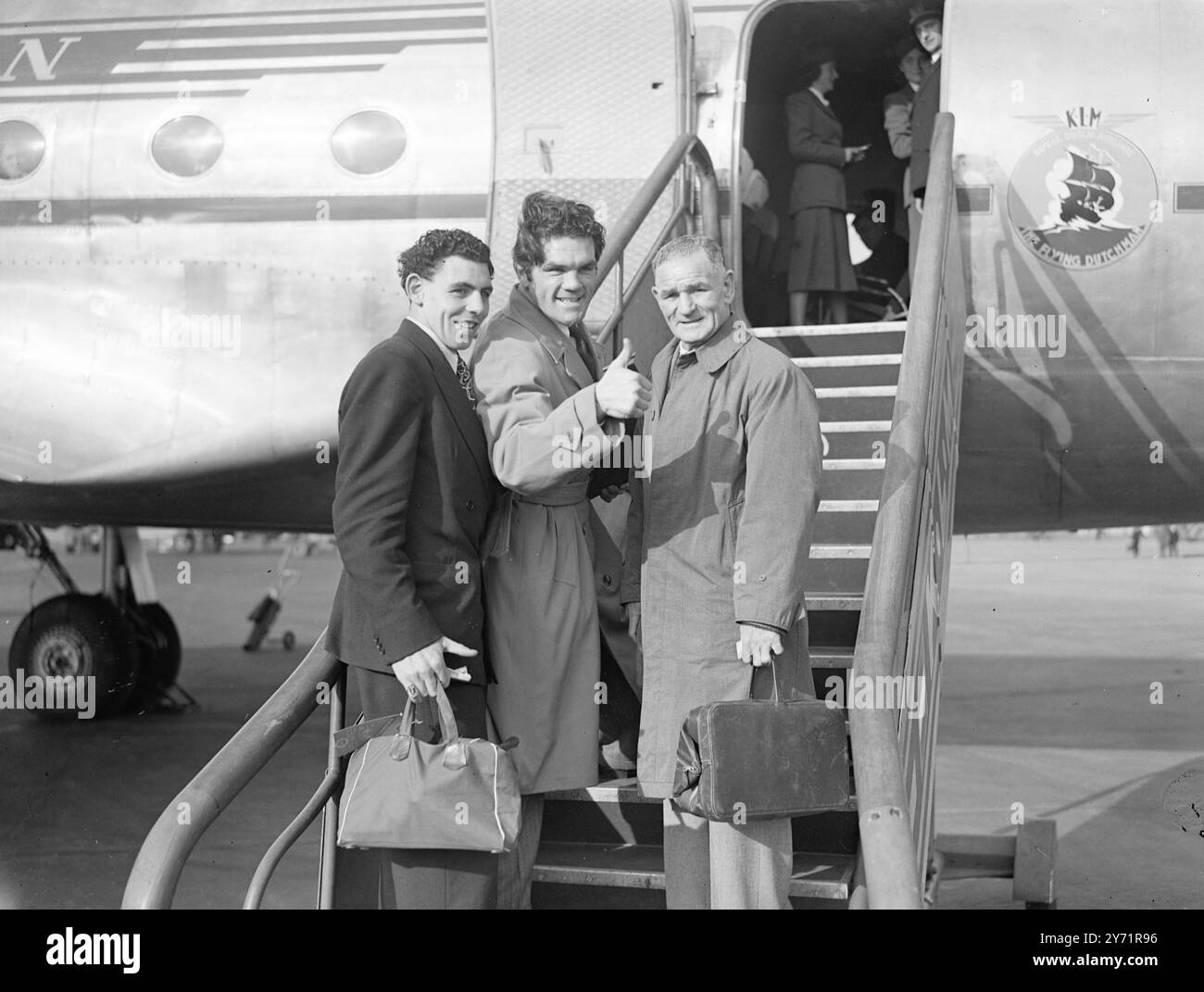 MILLS PART POUR L'AFRIQUE DU SUD FREDDIE MILLS , champion du monde des croiseurs de poids , a quitté l'aéroport de Londres pour s'envoler vers l'Afrique du Sud pour son combat avec Johnny Ralph , le détenteur du titre poids lourd sud-africain, à Johannesburg, le 6 novembre. Il était accompagné de son manager , Ted Broadribb , et Johnny Williams , qui doit se battre sur le même projet de loi que Mills. L'IMAGE MONTRE:- meilleure chance Freddie. Le champion Freddie Mills fait un adieu joyeux avant de monter à bord de l'avion pour l'Afrique du Sud. 20 octobre 1948 Banque D'Images