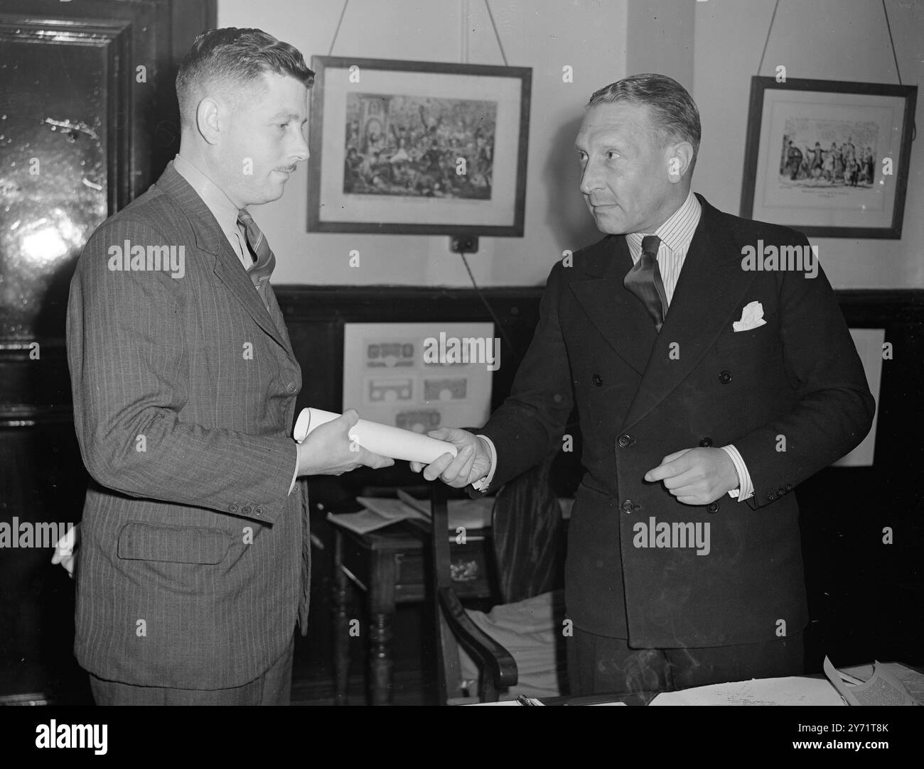 Le détective FC Powell, de Barnet, Herts, a reçu le prix de la Royal Human Society pour bravoure après avoir sauvé la vie d'un enfant de 4 ans de la noyade dans la Tamise à Twickenham. Images : - 'pour bravoure' - le commissaire adjoint RM Howe (à droite), présente le prix de la Royal Humane Society au détective FC Powell, à Scotland Yard. 14 juillet 1948 Banque D'Images