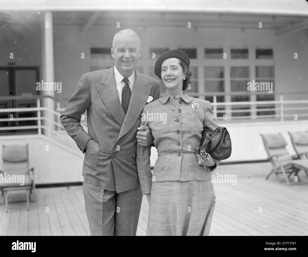 'Welcome Return' - Alfred Lunts arrive des États-Unis en arrivant à Southampton de New York, à bord du Cunard White Liner Queen Elizabeth, les partenaires de scène bien connus Mr et Mrs Alfred Lunt - Mrs Lunt est Lynn Fontaine - donne un sourire accueillant shorewards. 21 juillet 1948 Banque D'Images