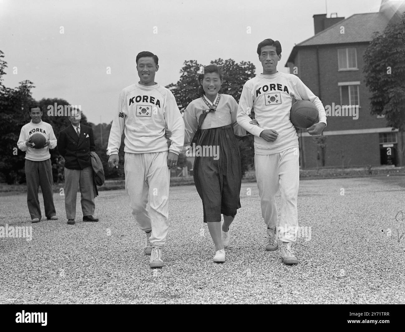 'Trois de Corée' - au camp olympique d'Uxbridge. Ici, avec 27 autres Coréens, l'équipe de l'équipe olympique de leur pays, est Pak Bong Sik, 17 ans, la seule fille au centre des Jeux Olympiques d'Uxbridge. Bong, qui est l'espoir de lancer le disque de Corée, est seulement 5 pieds 4 pouces. Elle peut lancer le disque à plus de 123 pieds. Les photos montrent : - Kang Bong Hyan (à gauche) et Ahm Byung Suk (à droite), tous deux de l'équipe coréenne de basket-ball, escortent Pak Bong Sik, la seule représentante de Corée, jusqu'au terrain d'entraînement du camp olympique d'Uxbridge. 15 juillet 1948 Banque D'Images 'Trois de Corée' - au camp olympique d'Uxbridge. Ici, avec 27 autres Coréens, l'équipe de l'équipe olympique de leur pays, est Pak Bong Sik, 17 ans, la seule fille au centre des Jeux Olympiques d'Uxbridge. Bong, qui est l'espoir de lancer le disque de Corée, est seulement 5 pieds 4 pouces. Elle peut lancer le disque à plus de 123 pieds. Les photos montrent : - Kang Bong Hyan (à gauche) et Ahm Byung Suk (à droite), tous deux de l'équipe coréenne de basket-ball, escortent Pak Bong Sik, la seule représentante de Corée, jusqu'au terrain d'entraînement du camp olympique d'Uxbridge. 15 juillet 1948 Banque D'Images