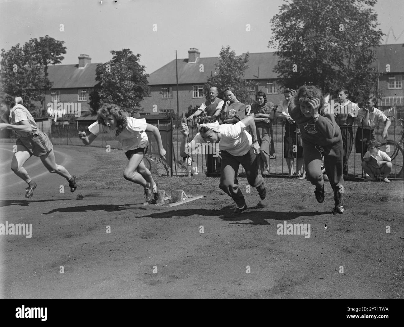 « Olympic Preview » regardé par les gens de Southall, ces trois membres de l'équipe olympique canadienne de piste s'entraînent sérieusement au Southall Recreation Ground. Donna Gillmore (à gauche) participera aux épreuves du 100 et du 200 mètres aux Jeux, et ses collègues sont Millie Cheater, de Vancouver (au centre), et Pat Jones, de New Westminster. 26 juillet 1948 Banque D'Images