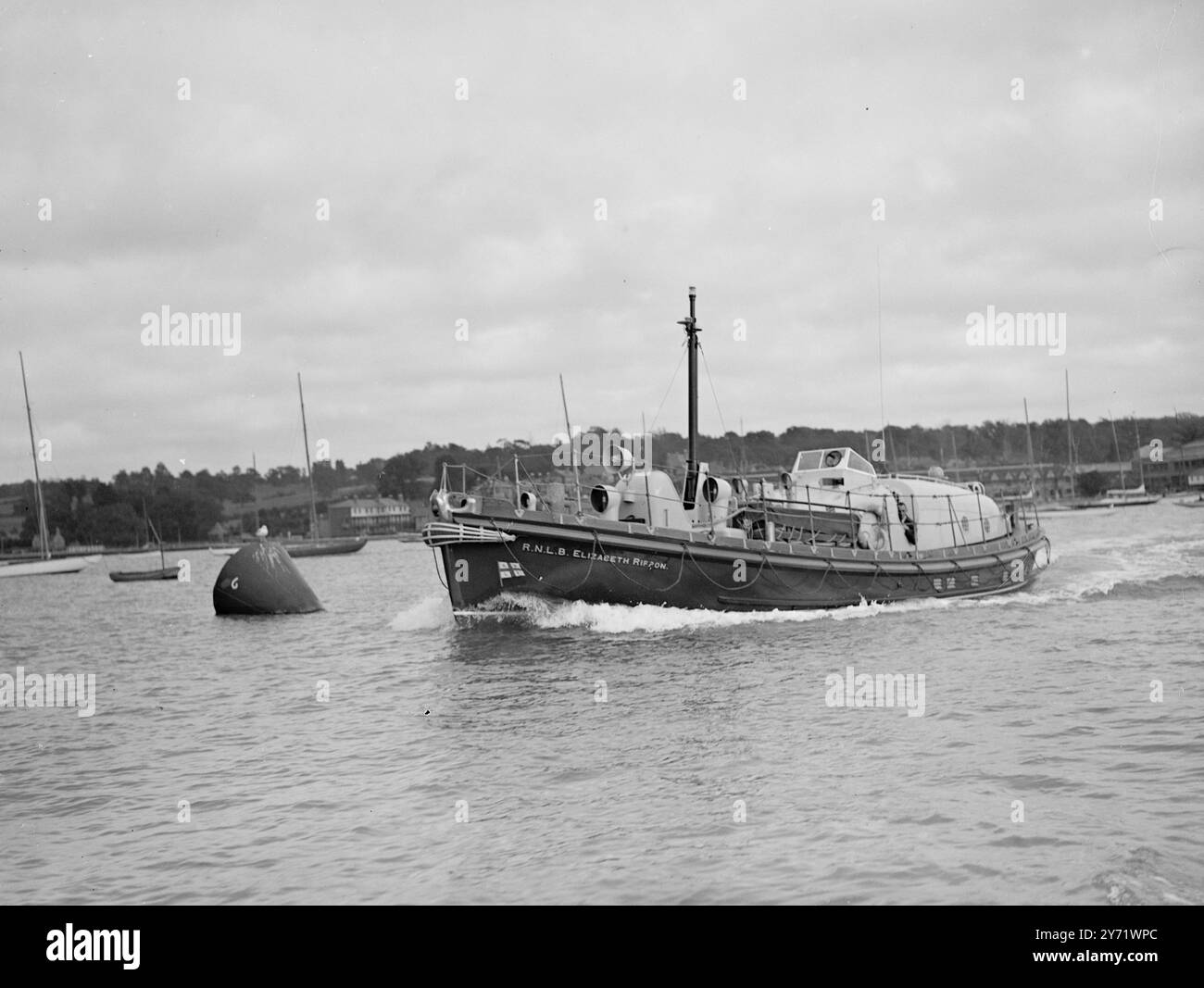 Nouveau Life Saver à l'essai. Un nouveau canot de sauvetage construit par la Royal National Lifeboat institution pour sa station à St Helier, Jersey, a fait un essai à Cowes avec l'inspecteur en chef adjoint des canots de sauvetage, le commandant T G Michelmore, au commandement. Il est le premier canot de sauvetage à être construit avec une cabine de pont, combiné avec d'autres nouvelles et intéressantes caractéristiques, qui comprennent un appareil de radiotéléphonie spécial, et pour la première fois dans les canots de sauvetage, des moyens de cuisson. La cabine du pont offre des sièges abrités pour 11 personnes de plus, avec de la place, si nécessaire, pour une civière. La photo montre : le St Helier Lifeboat Underg Banque D'Images