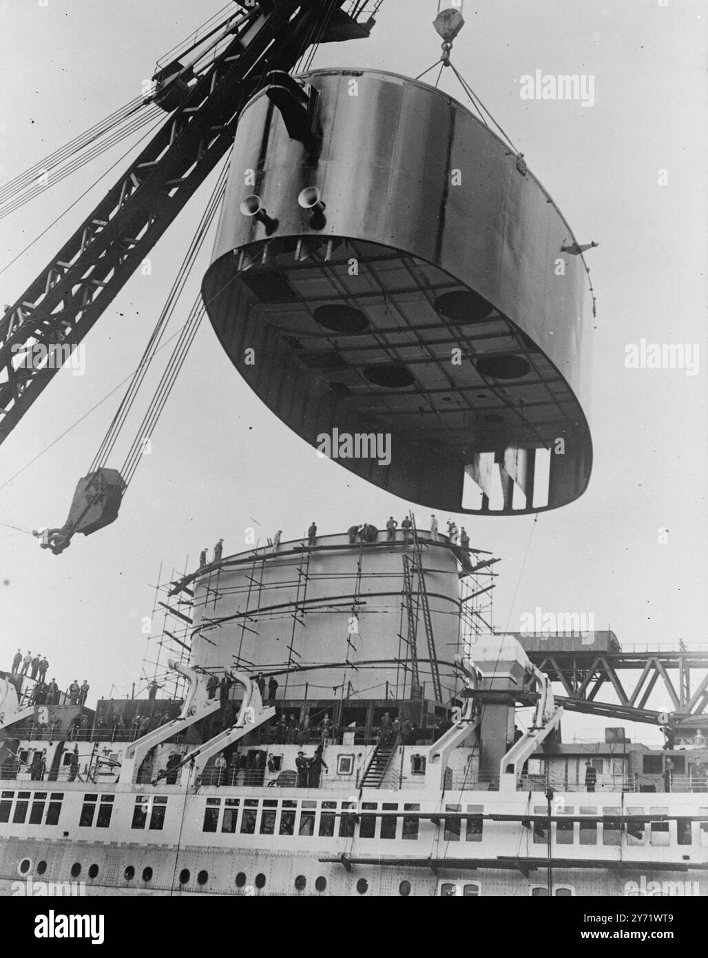 Le plus grand entonnoir de navire du monde. La dernière section de ce que l'on croit être le plus grand entonnoir jamais construit a été installée aux chantiers navals de Clydebank le 26 août, sur le Cunard White Star Liner Caronia qui sera l'un des plus grands et des plus réguliers gagnants de dollars de Grande-Bretagne. Le paquebot sera mis en service dans quelques mois, alors qu'il en est aux dernières étapes de construction du bassin d'aménagement de Messers John Brown and Co. Des milliers d'Américains voyageront avec elle à la fois à travers l'Atlantique et en croisières. La dernière section de son entonnoir a été aujourd'hui balancée à bord et 'accouplée' avec la structure déjà en pl Banque D'Images