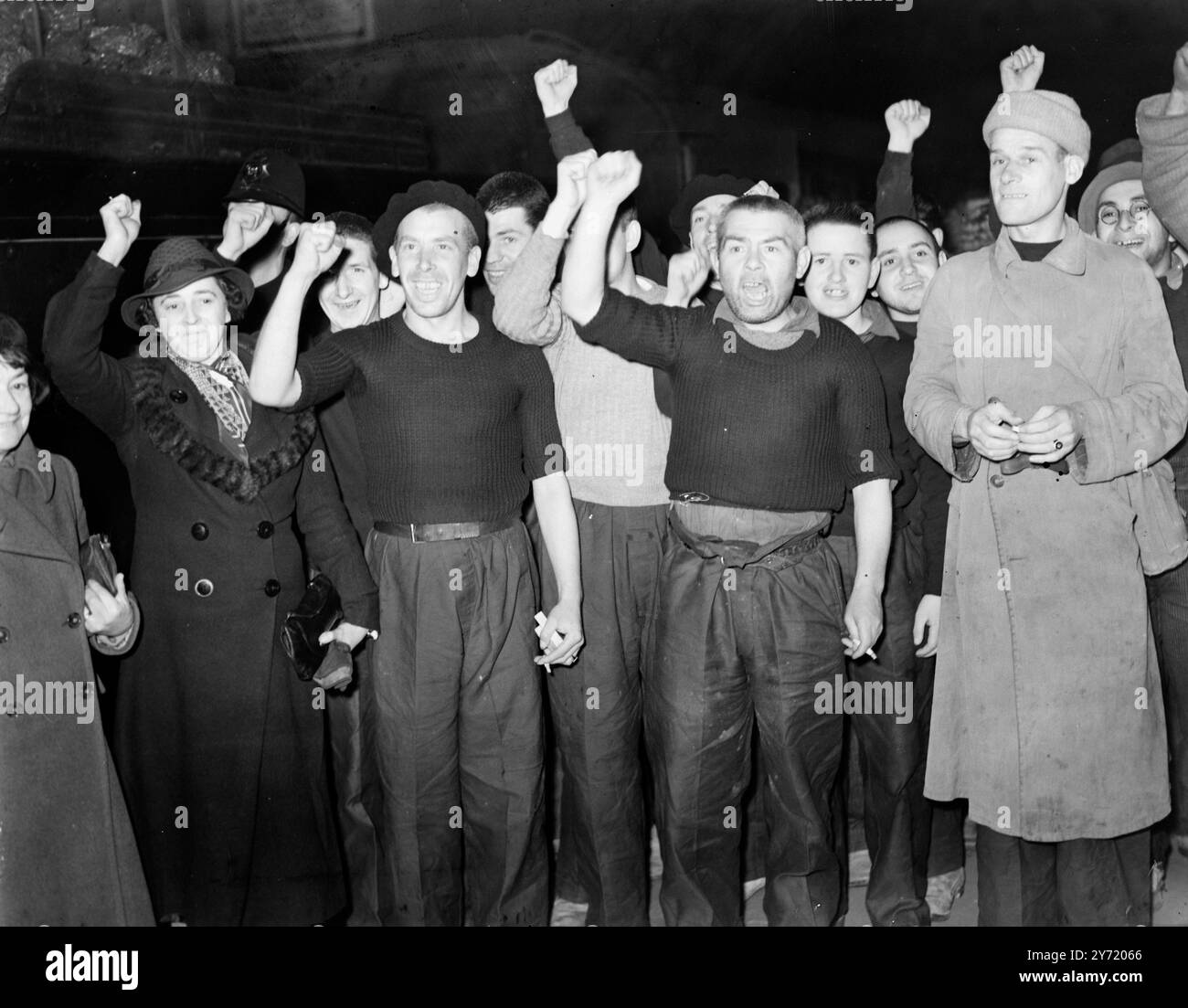 LES PRISONNIERS BRITANNIQUES LIBÉRÉS PAR FRANCO ARRIVENT CHEZ EUX. Soixante-sept volontaires britanniques libérés par le général Franco en échange d'Italiens aux mains du gouvernement espagnol sont arrivés à Victoria Station , Londres , à leur retour chez eux . Ils avaient été emprisonnés à Saint-Sébastien. IMAGES MONTRENT :- les membres de la partie donnant le salut du poing serré à l'arrivée à Victoria . 7 février 1939 Banque D'Images