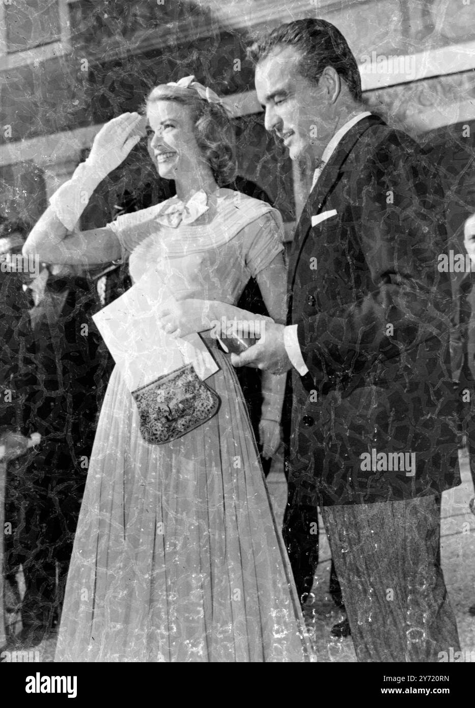 Mardi, sous un soleil éclatant, le Prince Rainier III de Monaco et sa fiancée Grace Kelly, actrice de cinéma, ont reçu des invités dans l'une des cours intérieures. Les visiteurs ont pu voir un certain nombre de cadeaux de mariage lors de leur réception. Photos : - radieusement heureuse, Grace Kelly regarde la scène dans la cour, avec le Prince debout à ses côtés. 19 avril 1956 Banque D'Images