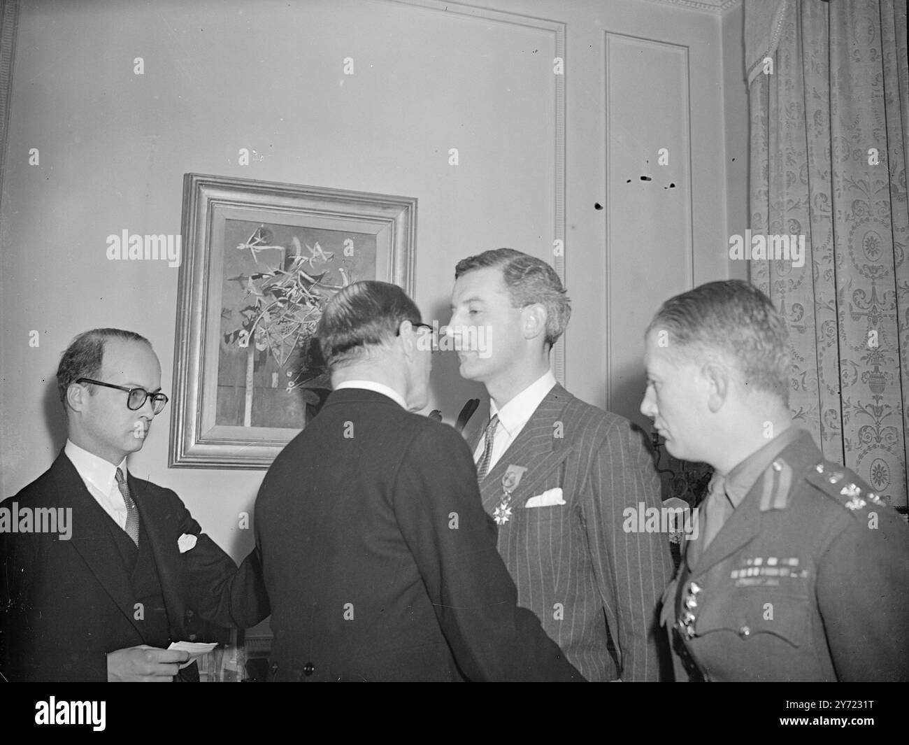 Décoration française pour Lord Lovat. Lord Lovat, qui commandait la 1re Brigade Commando à laquelle était rattaché le 1er Bataillon de commandes françaises (Fusilliers-marins) lors du débarquement de Normandie, fut investi officier de la Légion d'honneur et de la Croix de Guerre à Palm par l'ambassadeur de France H. E René Massigli, KBE, lors d'une investiture à l'ambassade de France à Londres aujourd'hui (vendredi). Spectacles de photos : Lord Lovat est félicité à la manière gaïlique par l'ambassadeur de France après l'investiture à Londres aujourd'hui (vendredi). 5 mars 1948 Banque D'Images