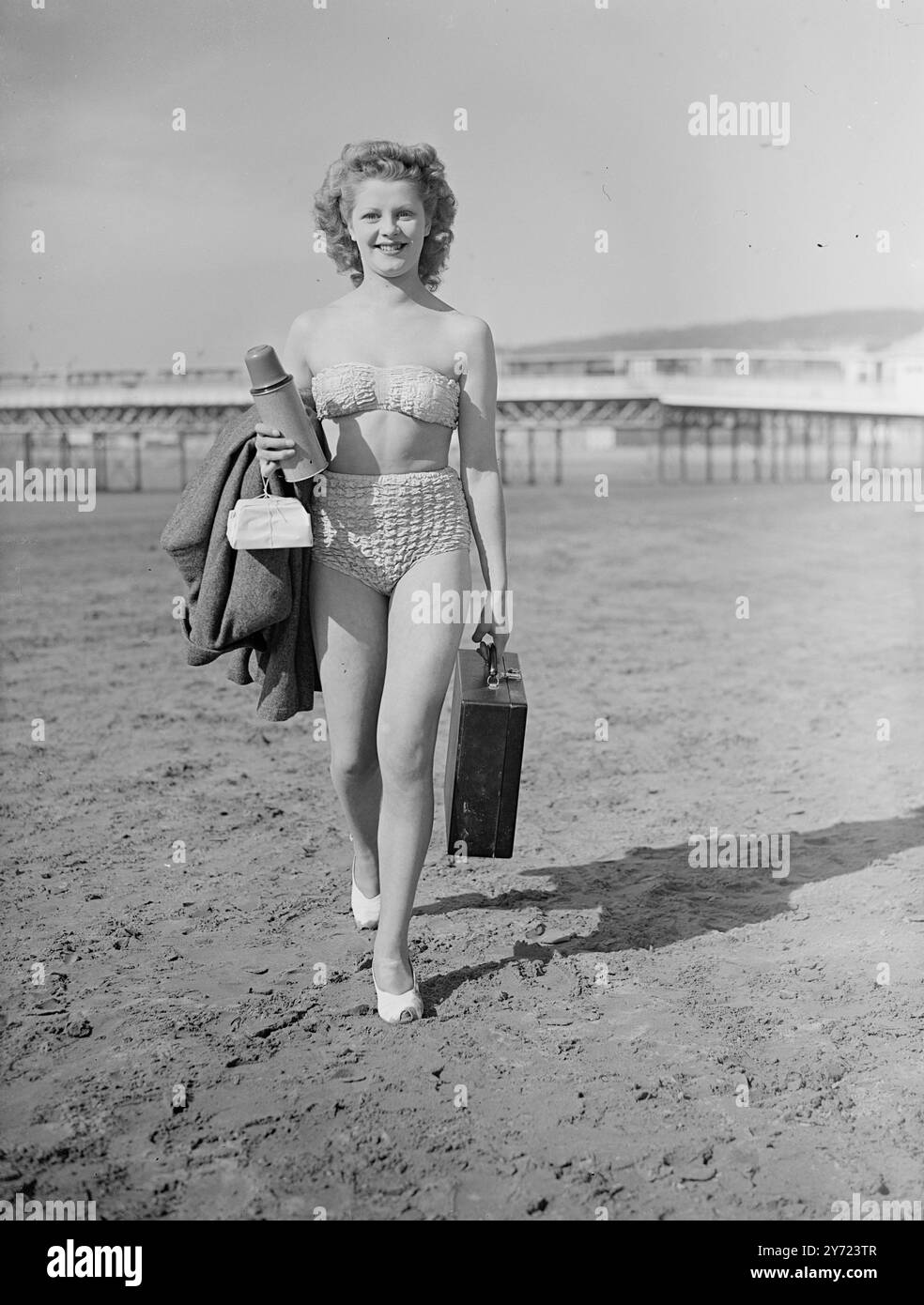 À vous de remettre le sable. Slim Brenda Bartlett, Weston Super-Mare officier ouvrier est plus une 'épaule bronzée' que 'White col 'ouvrier ces jours-ci alors qu'elle emmène son graveur portable à la mer pour travailler. Profitant du beau temps printanier, Brenda, convenablement vêtue pour son «bureau» en plein air dans un élégant deux pièces apporte à la fois lettres et déjeuner sur la côte de Weston Super-Mare, et bronzage comme elle tape. 14 mars 1948 Banque D'Images