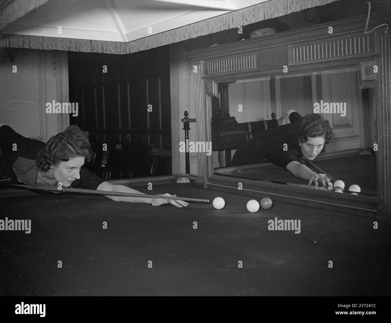 Billard Brunette Brunette Joyce Gardener, sept fois championne de billard féminin, s'entraîne tranquillement pour reprendre sa « touche » pour les prochains championnats. Joyce est juste sortie de l'hôpital après une opération sévère, et surprend les médecins avec la rapidité de son rétablissement. 25 février 1948 Banque D'Images